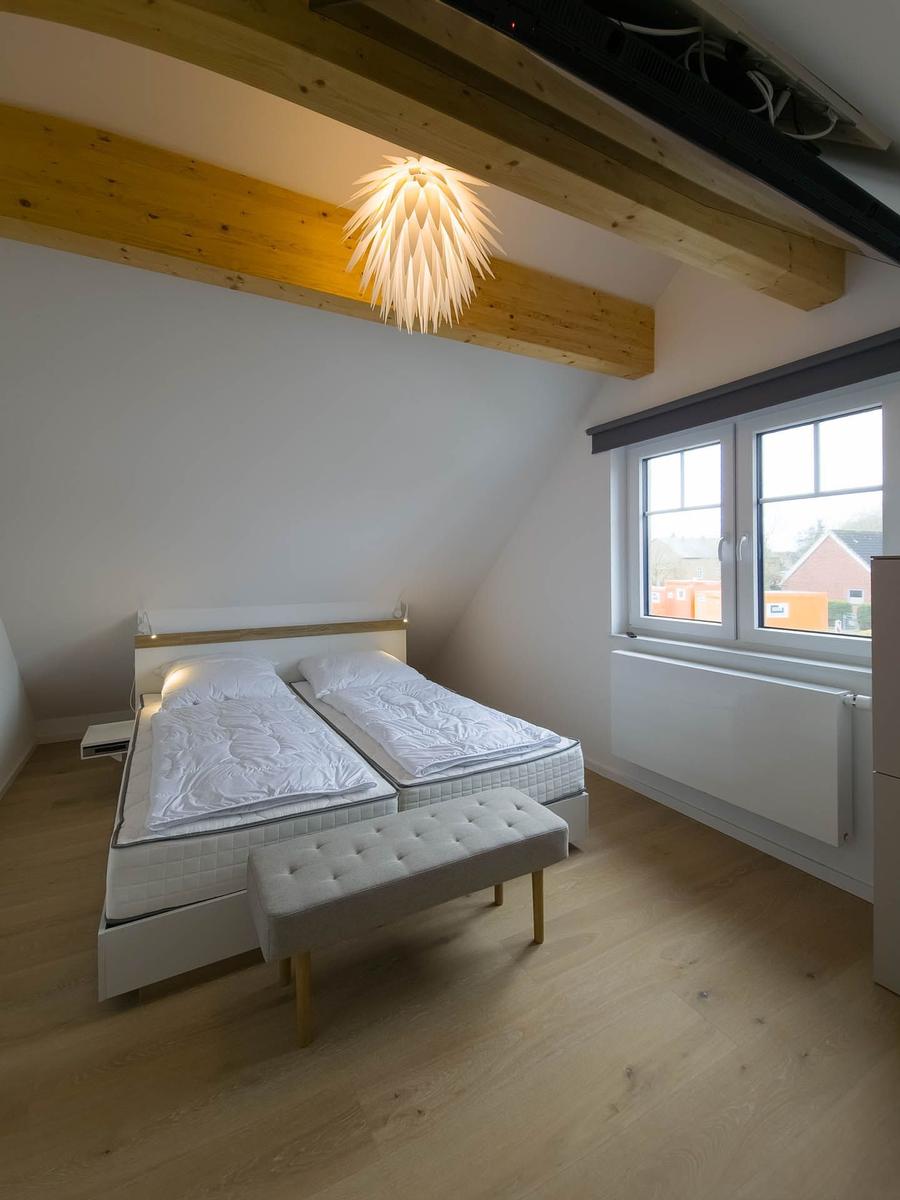 Schlafzimmer mit Doppelbett, Holzbalken und Fenster