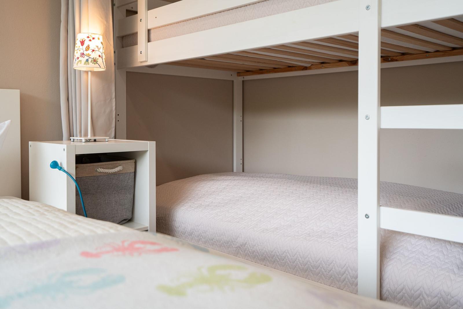 Ein Schlafzimmer mit einem Doppelstockbett und einem Nachttisch mit Lampe.