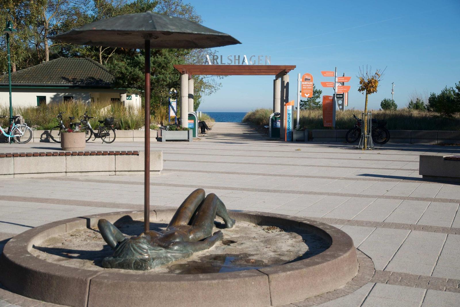 Bronzefigur in Brunnen, Blick auf Karlshagen mit Strandweg und Meer