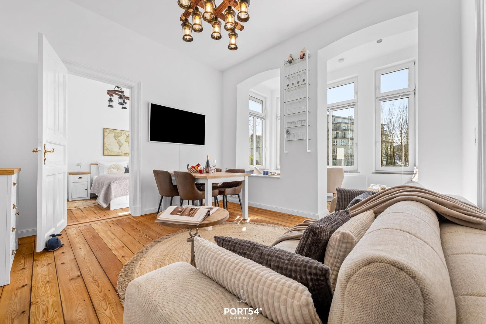 Wohnzimmer mit Sofa, Esstisch und Blick in Schlafzimmer.