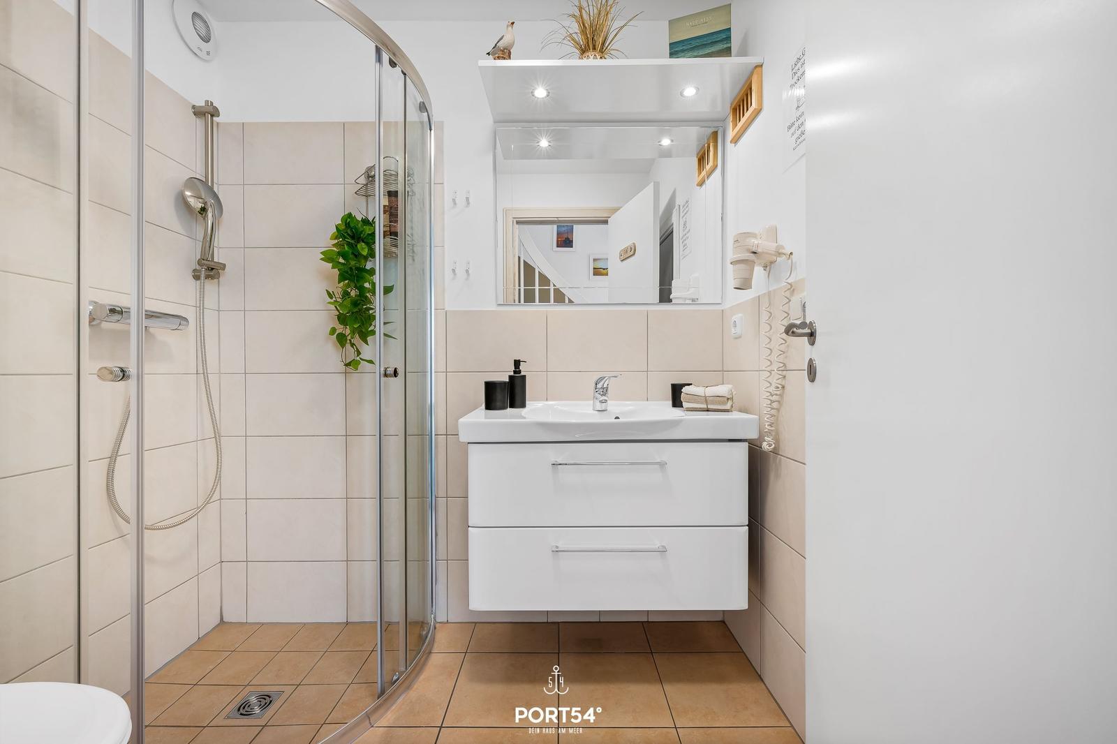 Bathroom with shower, sink, and mirror