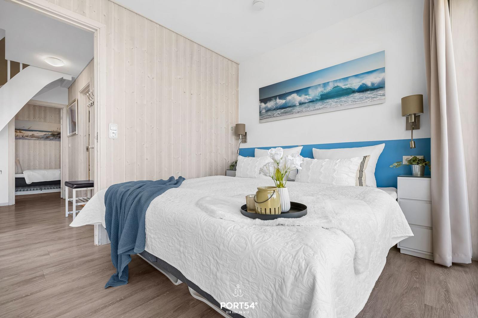 Bedroom with bed, wall art, and nightstand. Wooden wall and floor.