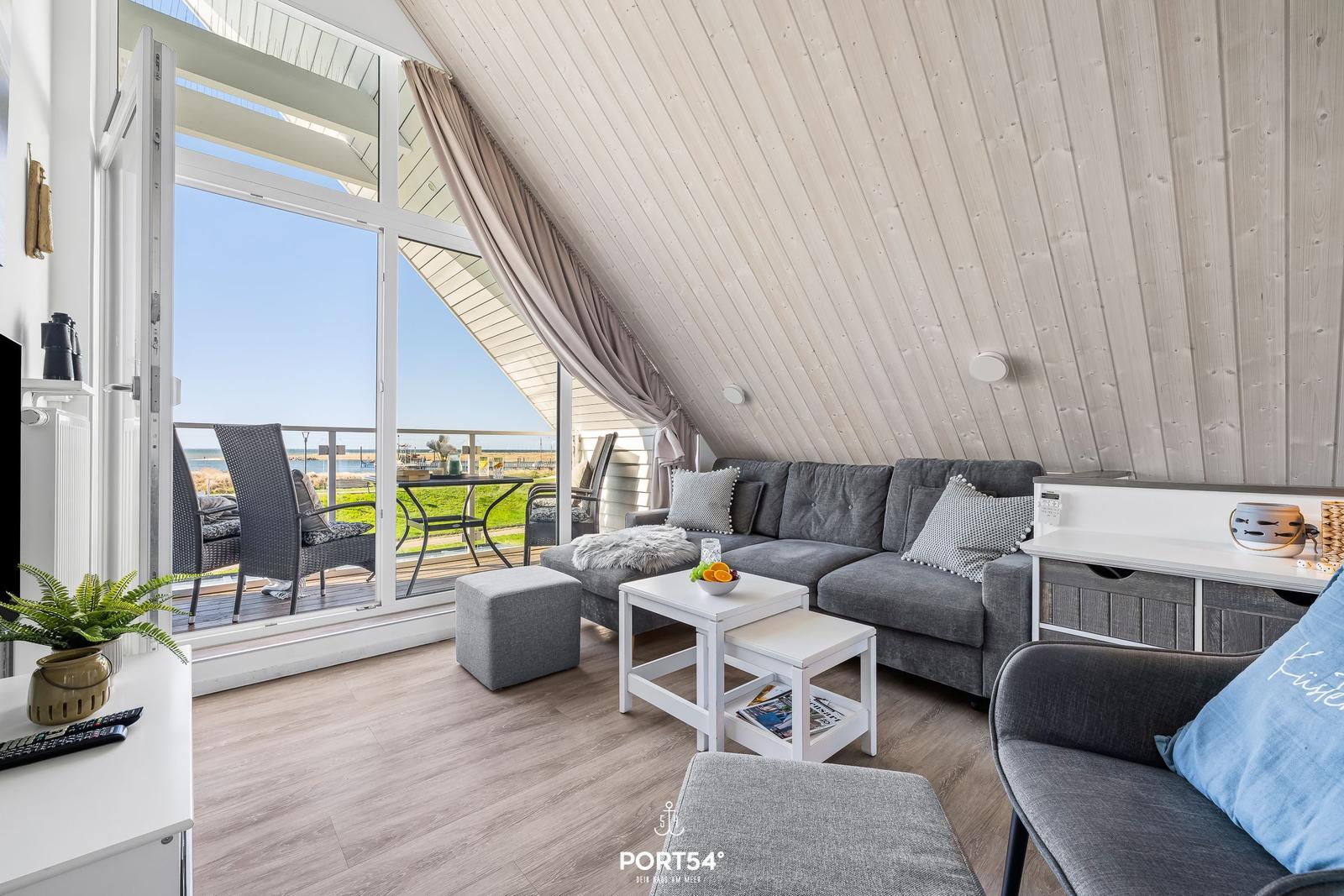 Living area with sofa, table, and balcony view of the sea.