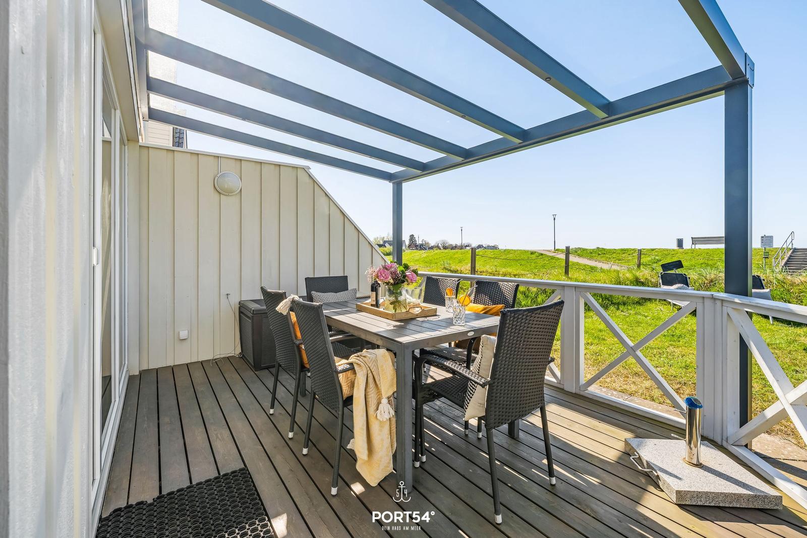 Terrace with seating area and view of green field.