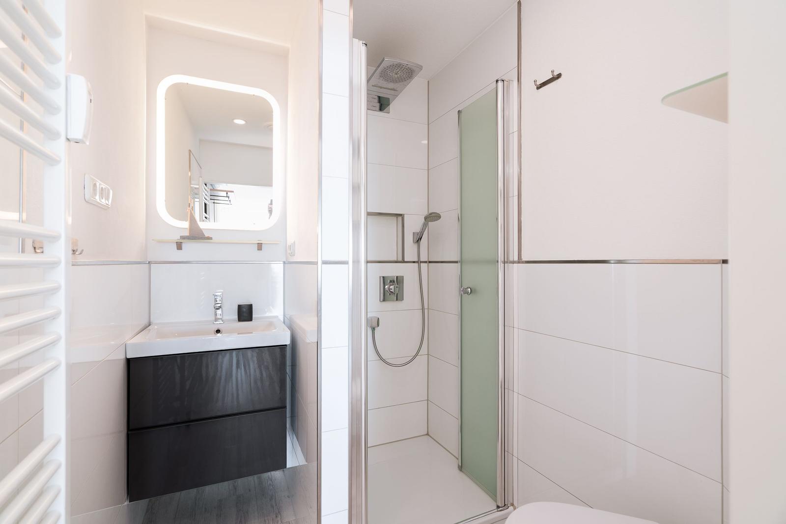Bathroom with shower, sink, and mirror