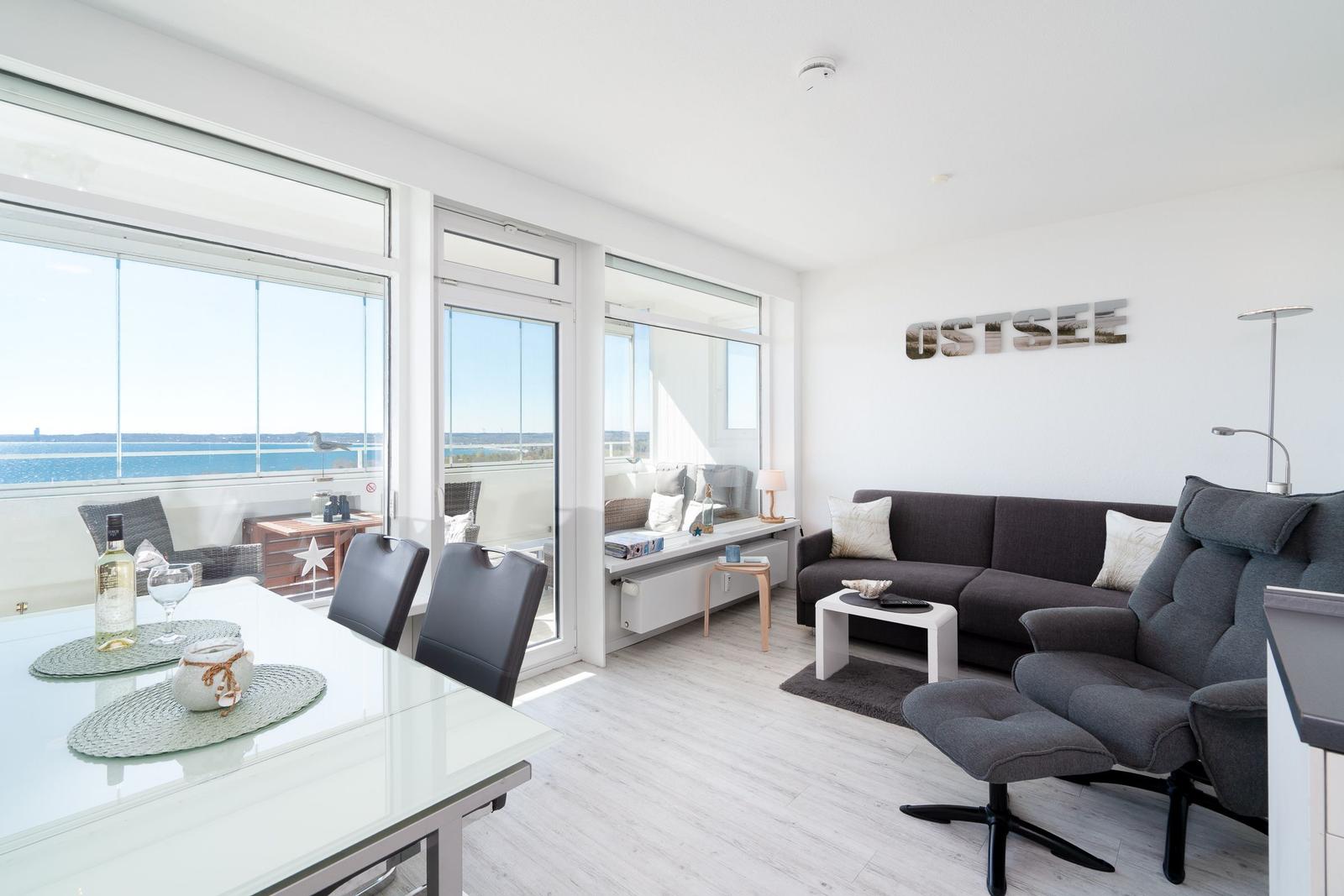 Living and dining area with Ostsee view. Sofa, dining table, and balcony.