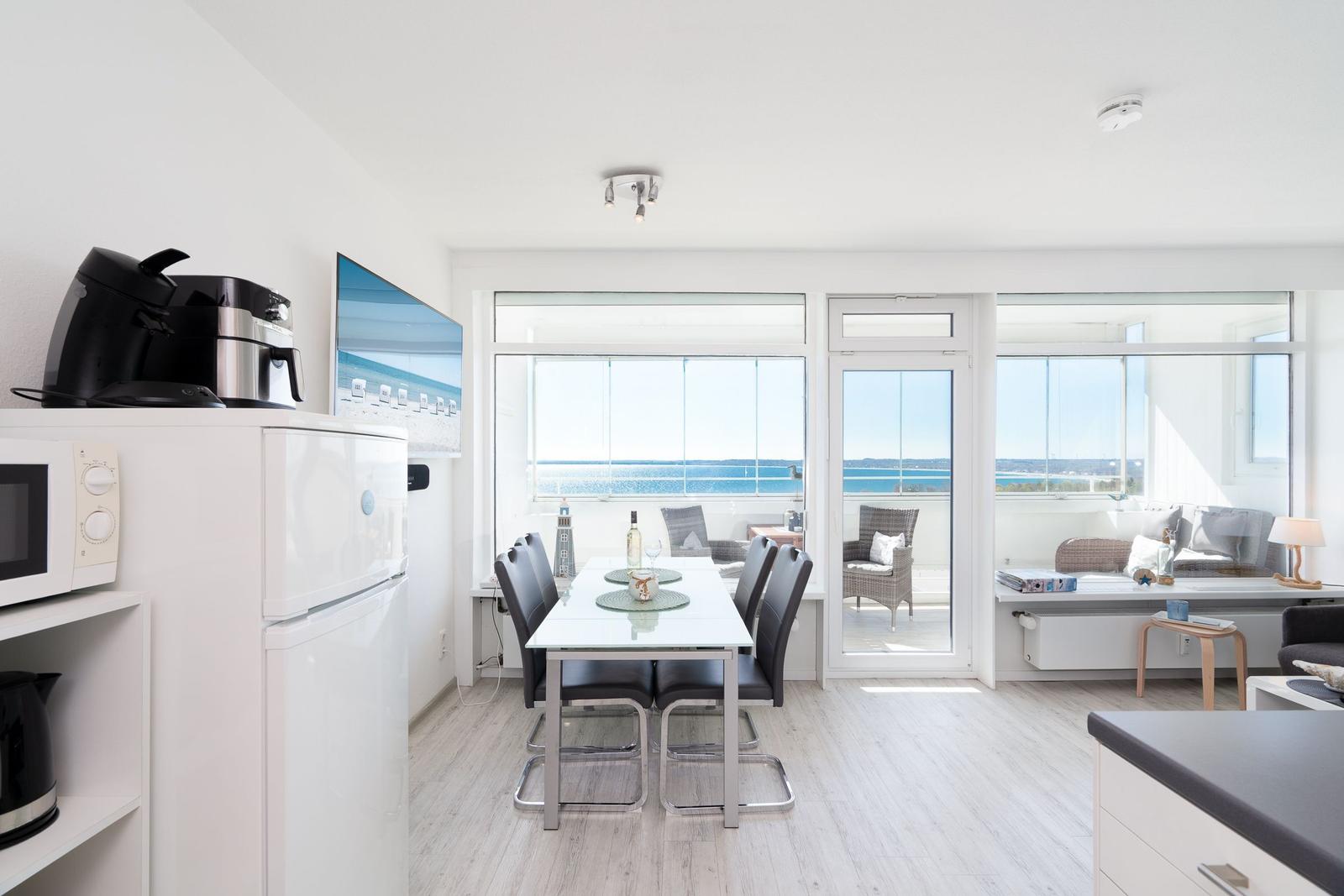 Kitchen with dining table, TV, and sea view.