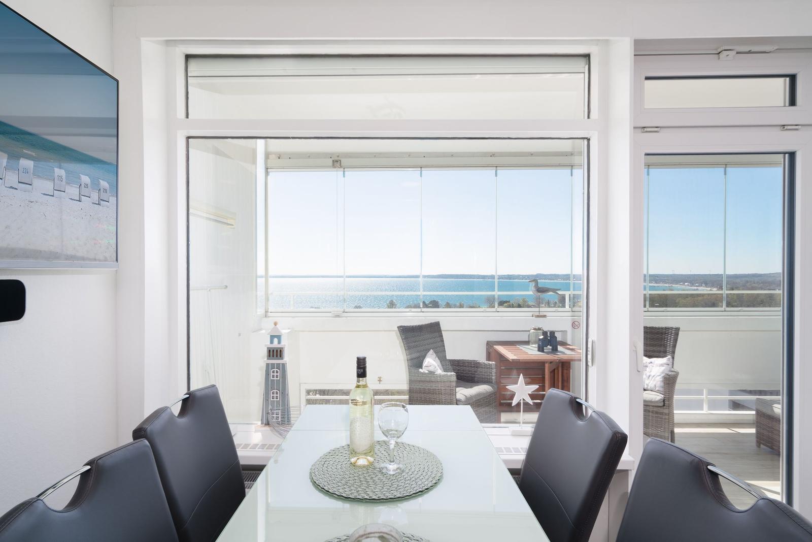 Dining room with sea view and balcony seating area.