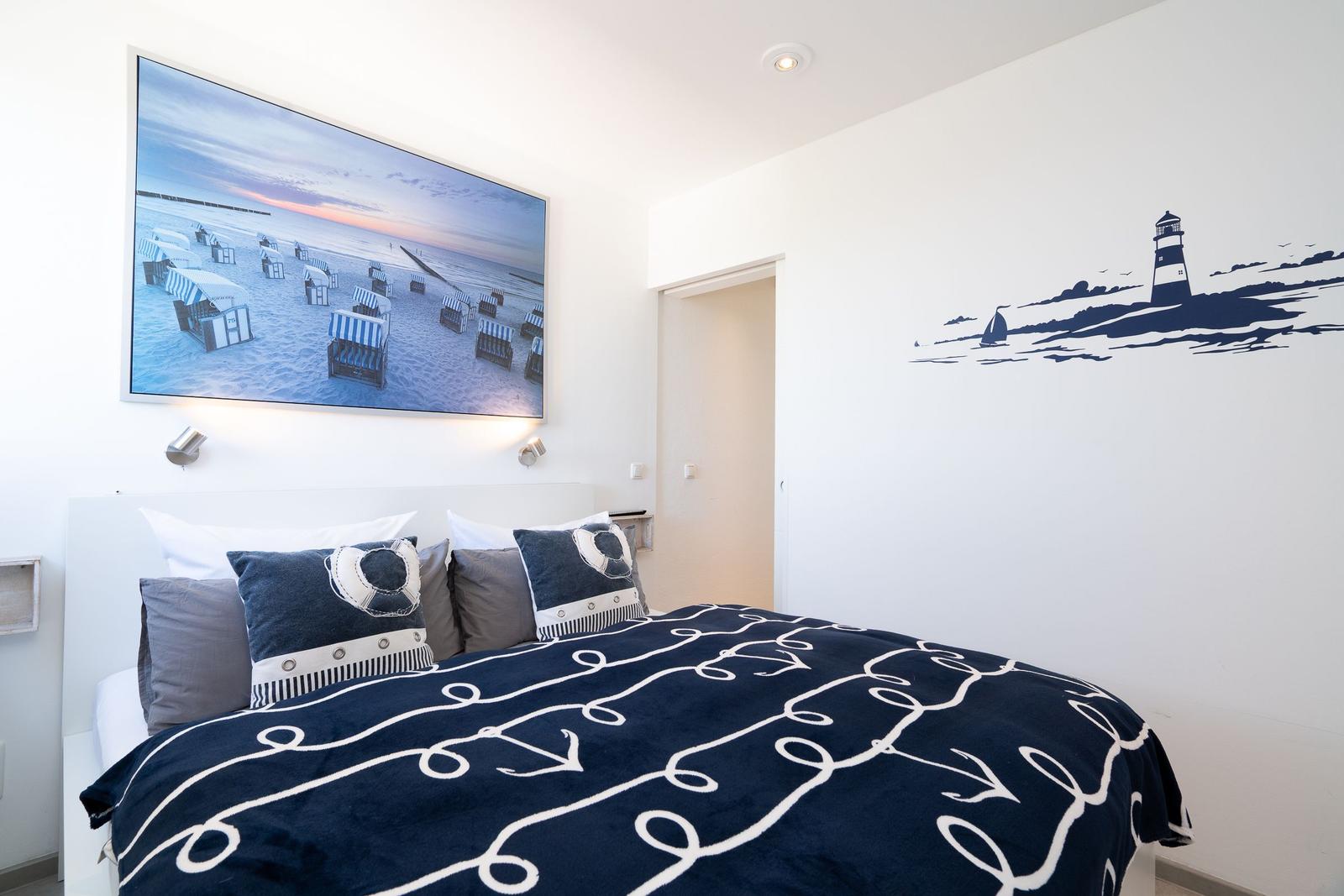 Schlafzimmer mit Bett, Wandbild und Leuchten an der Wand.