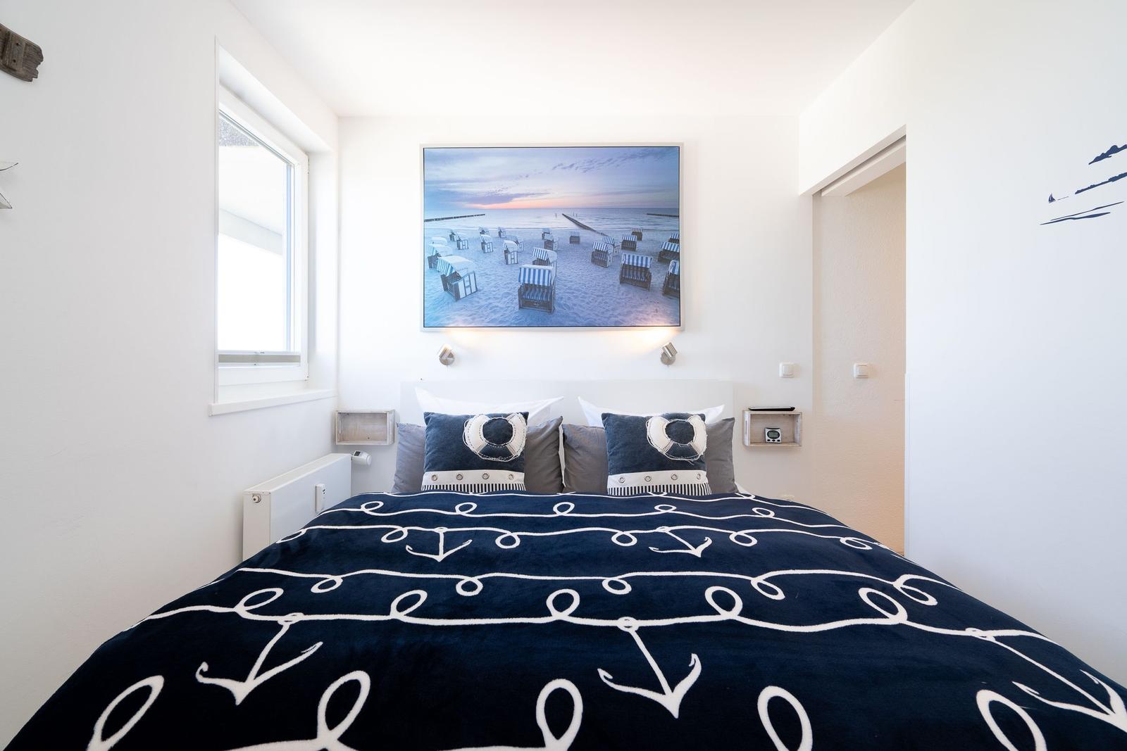 Schlafzimmer mit Bett, Wandbild und Fenster.