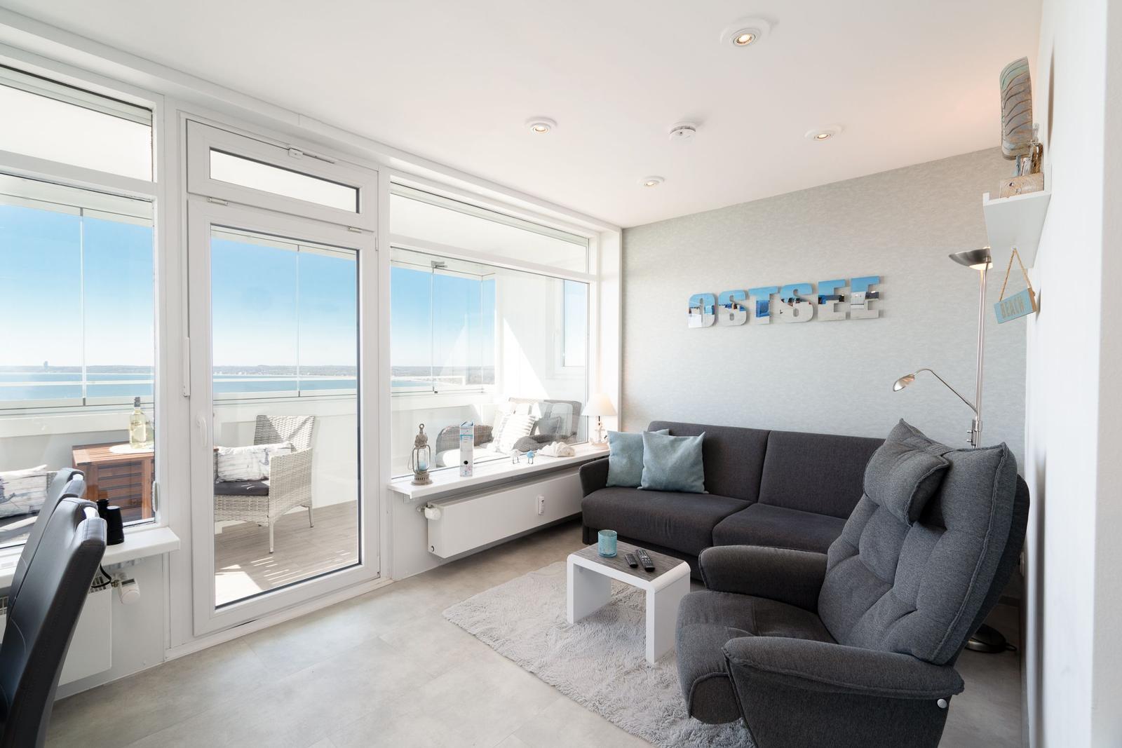 Wohnzimmer mit Blick auf den Ostsee, Sofa, Sessel und Balkon.
