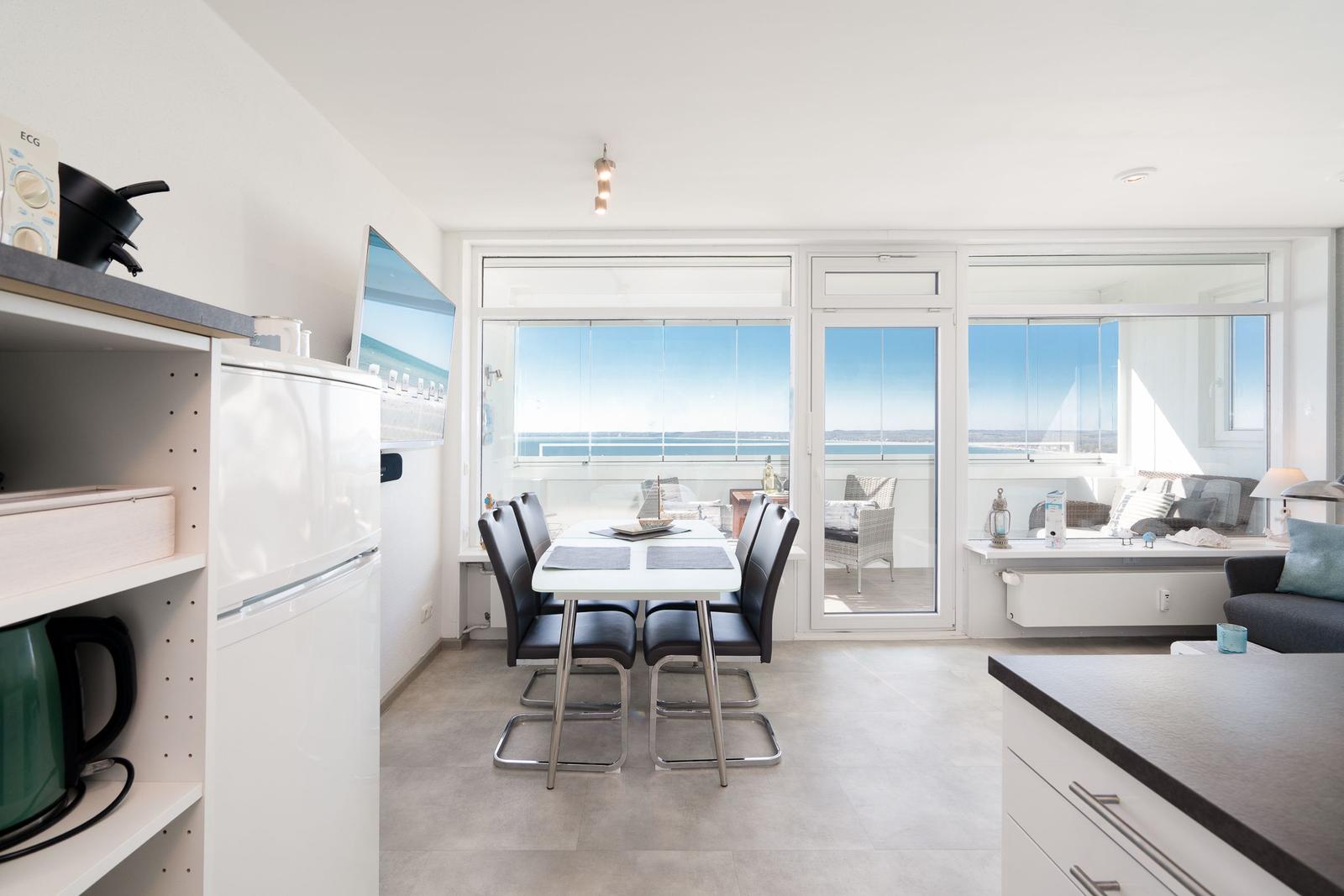 Modern eingerichteter Wohnbereich mit Essbereich und Blick auf das Meer.