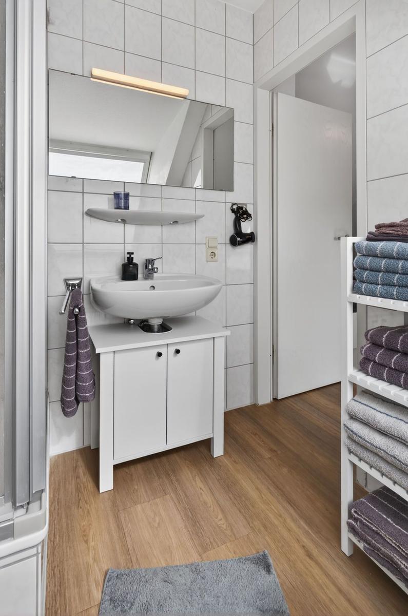 Bathroom with sink, mirror, and towel rack.