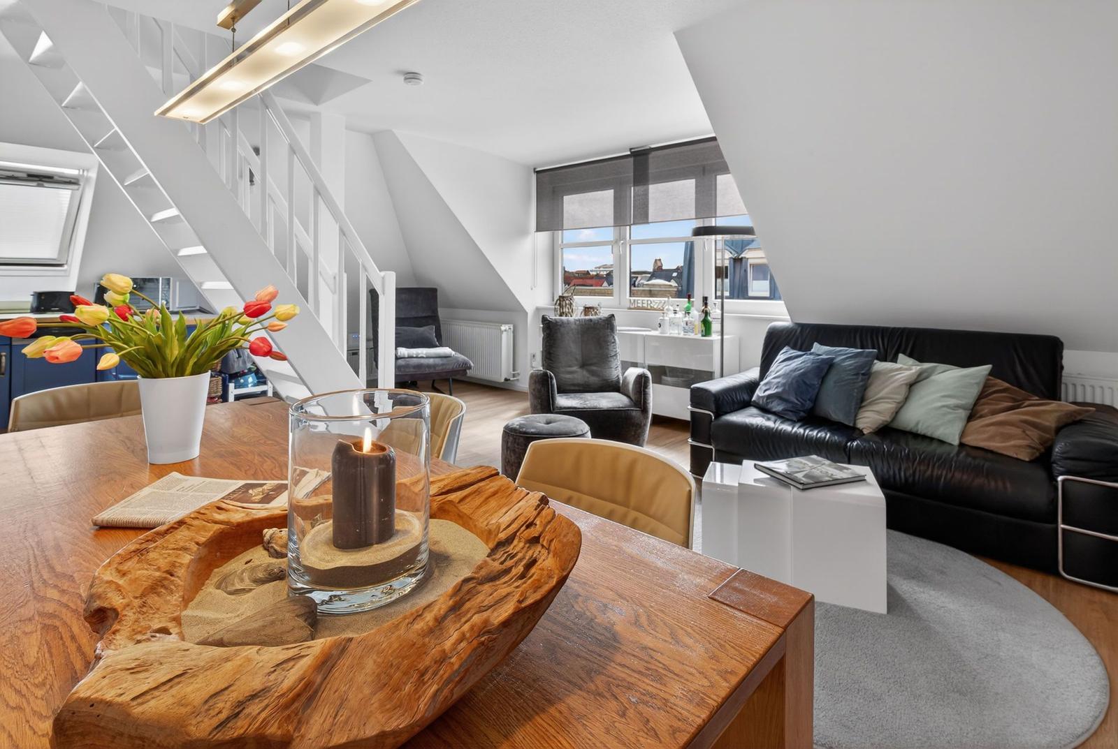 Living area with sofa, chairs, and table with wood decoration.