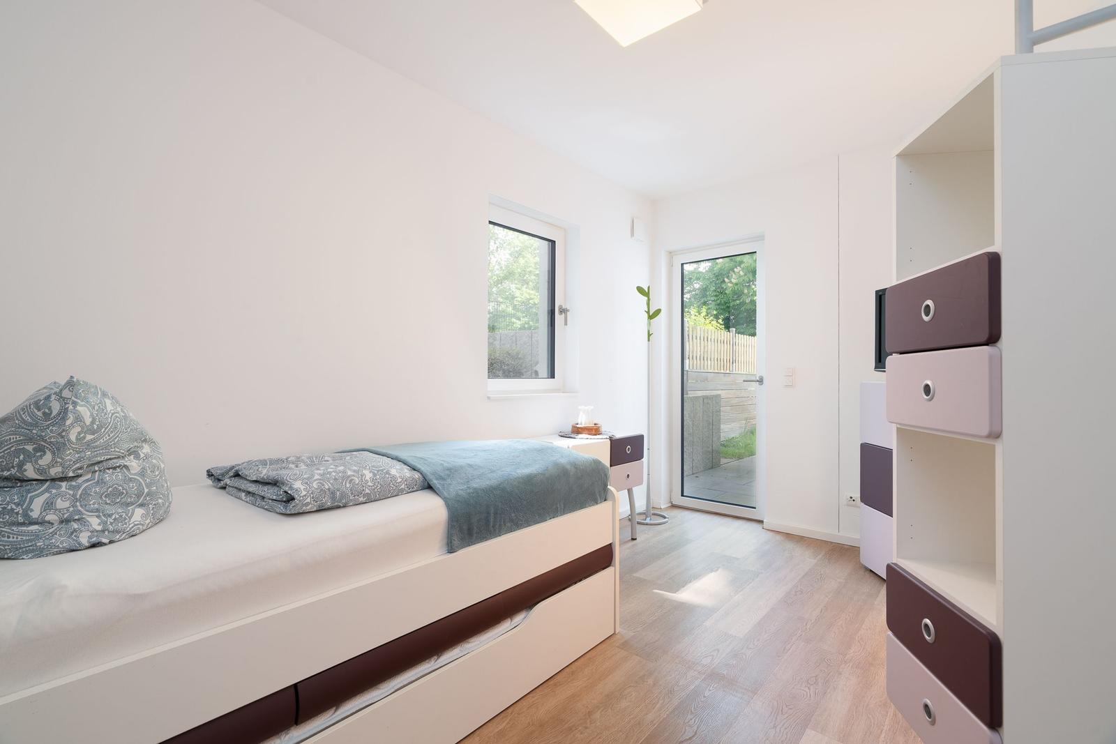 Bedroom with bed, wardrobe, and window to terrace.