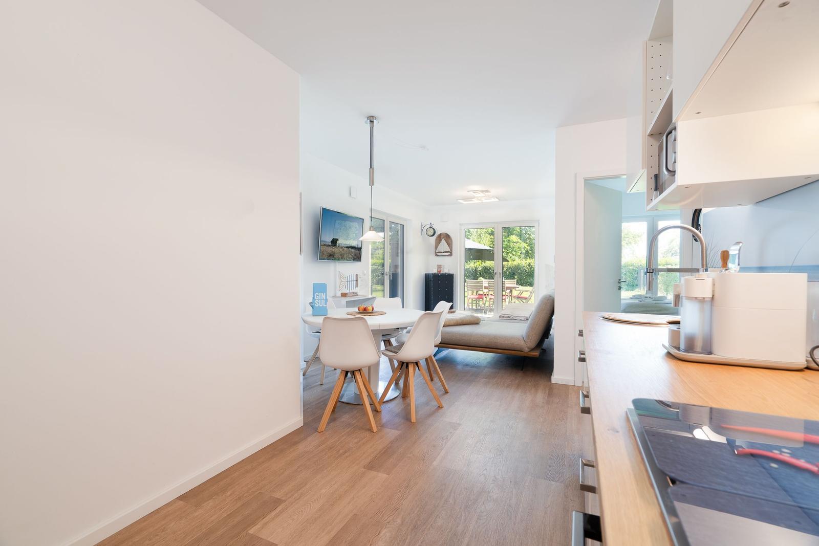 Kitchen with wooden countertop, dining area with table and chairs, view of terrace