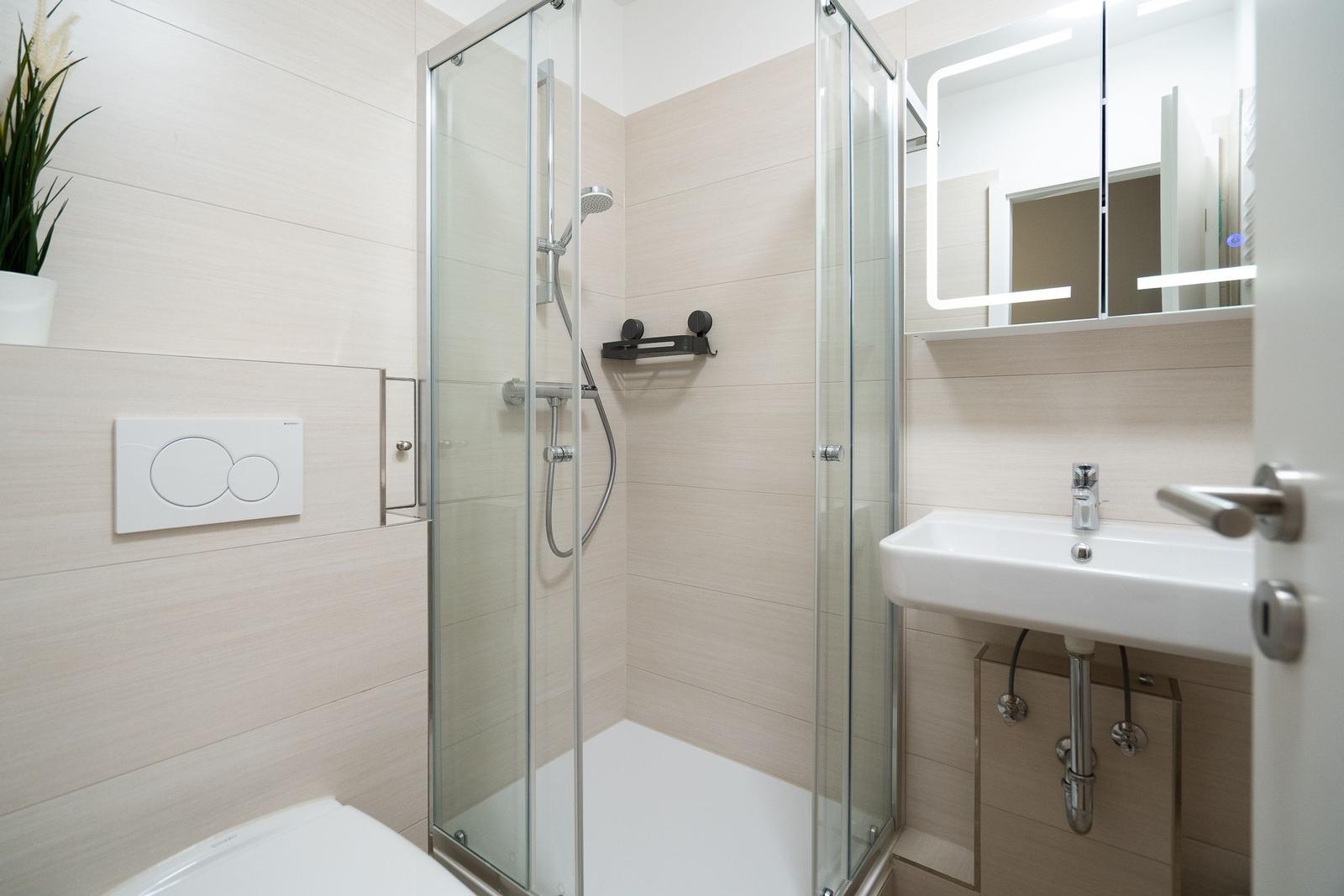 Modern bathroom with shower, sink, and toilet.