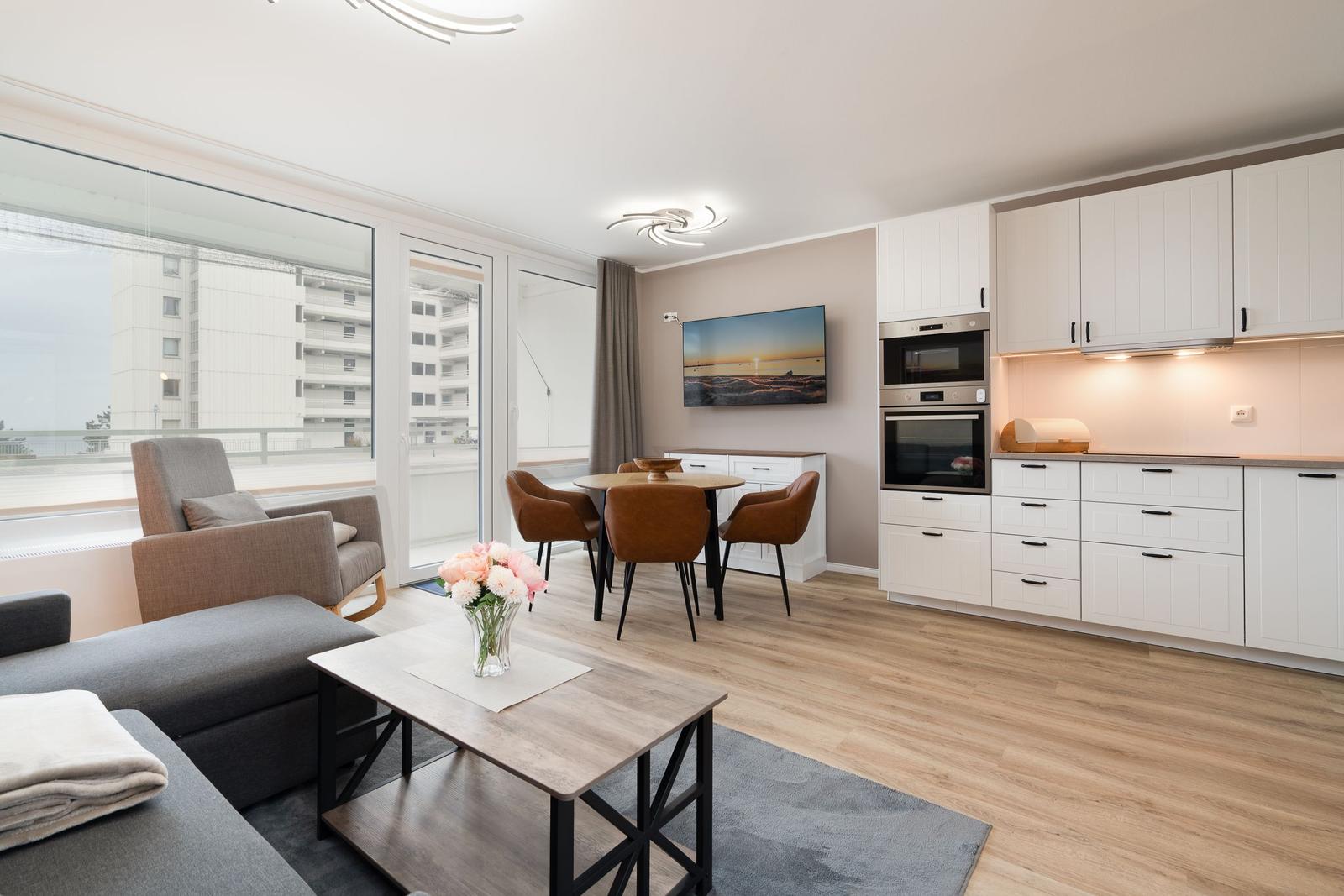 Living and dining area with modern kitchen and large window view.