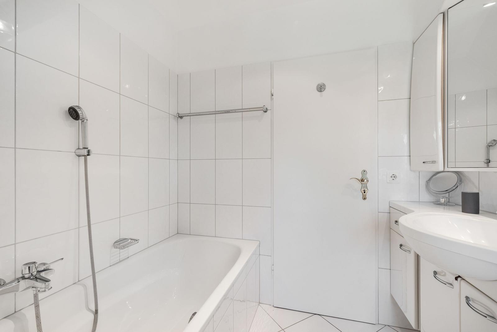 Badezimmer mit Badewanne, Dusche, Waschbecken und Spiegelschrank.