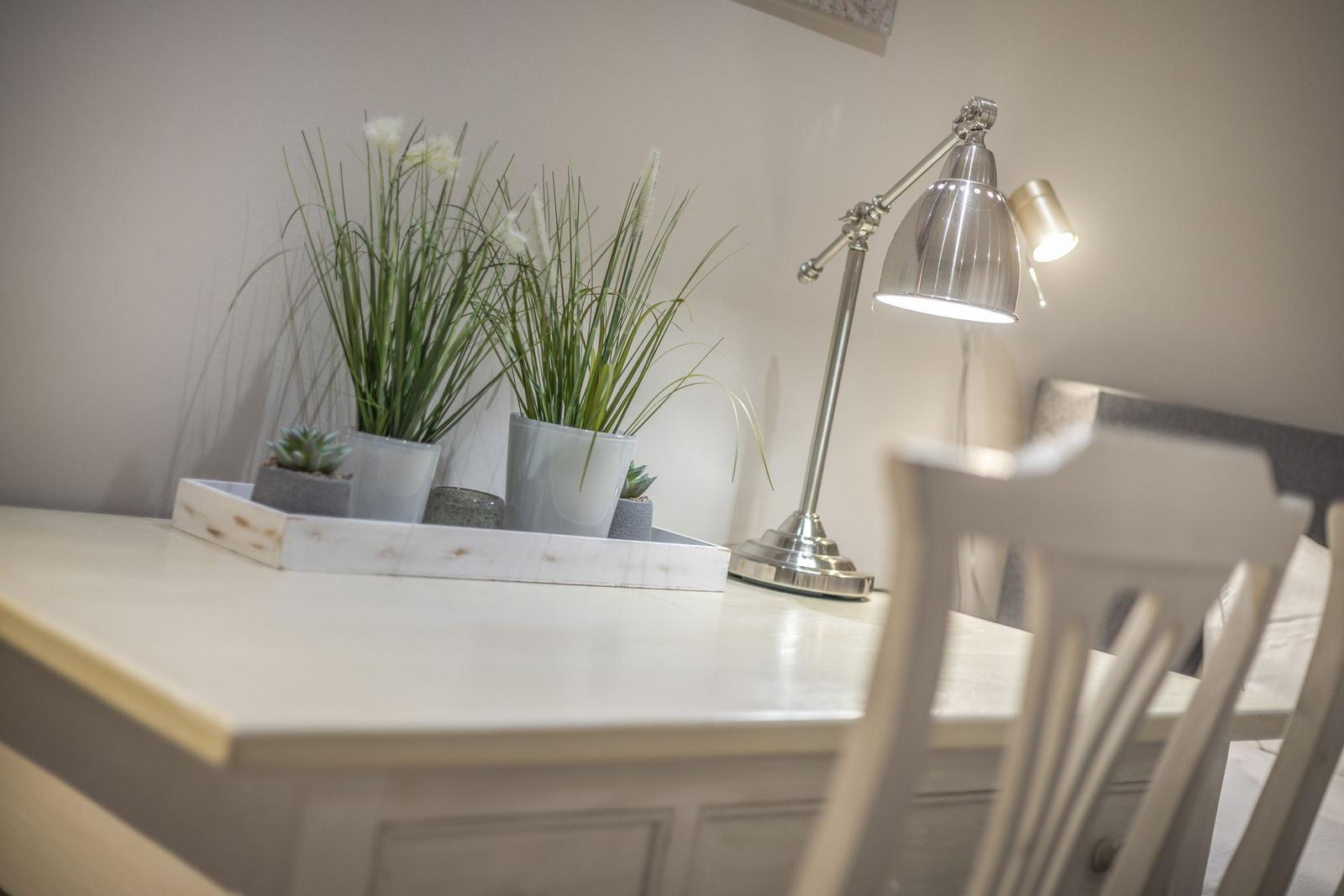 Schreibtisch mit Lampe, Pflanzen und Stuhl im Raum