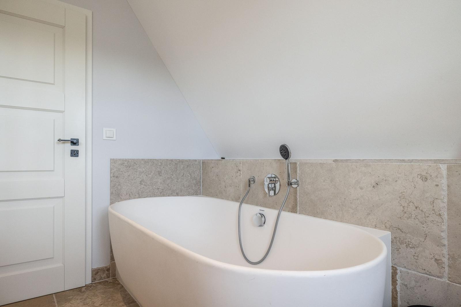 Bad mit freistehender Badewanne und Duschkopf