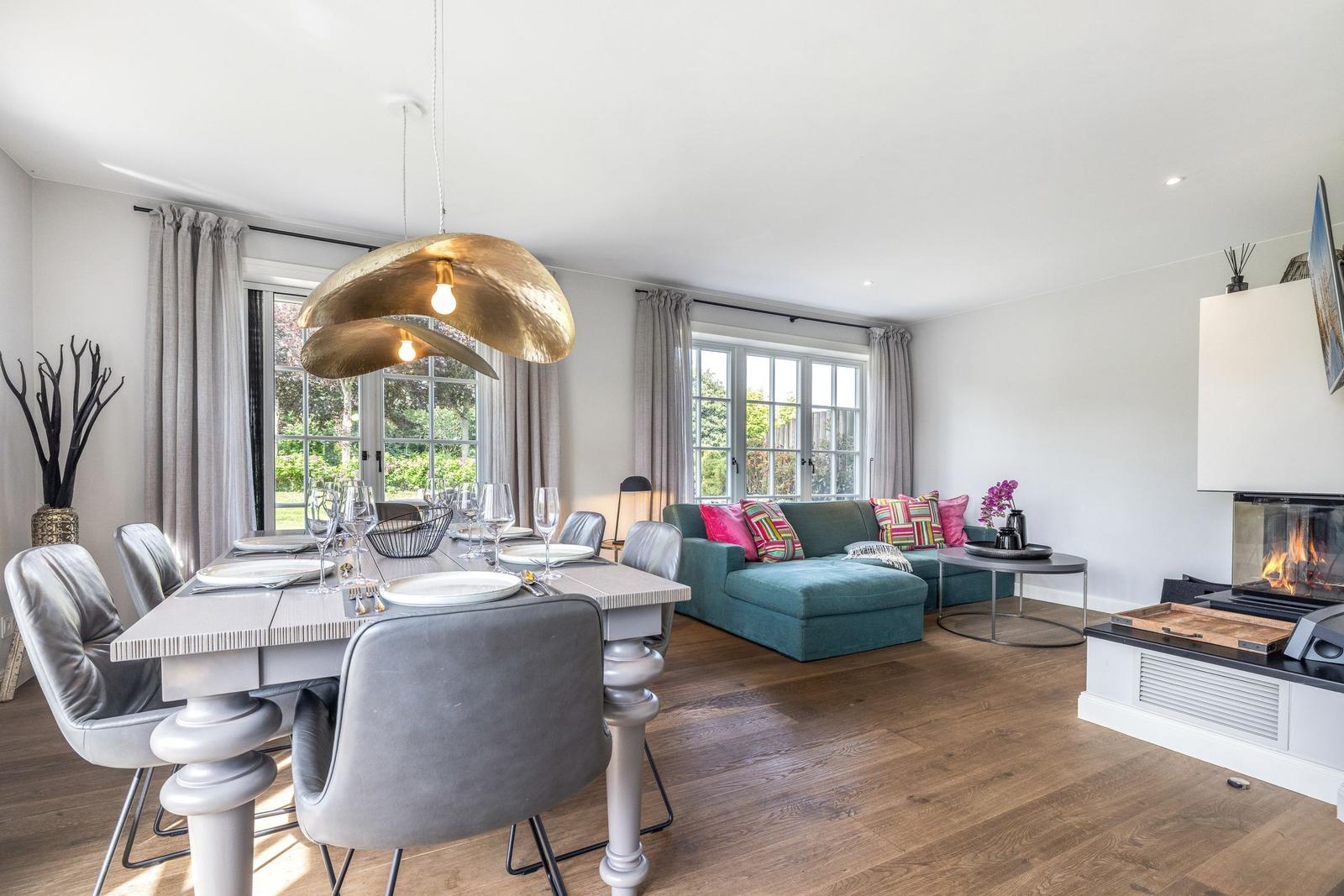 Essbereich mit Tisch und Stühlen, Wohnbereich mit Sofa und Kamin