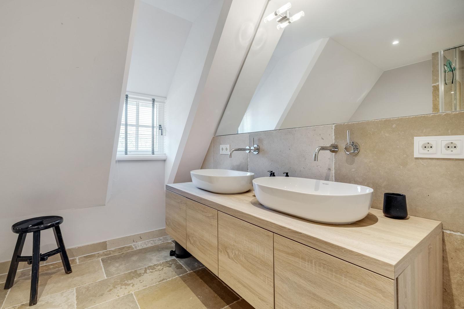 Badezimmer mit zwei Waschbecken, Spiegelschrank und Fenster