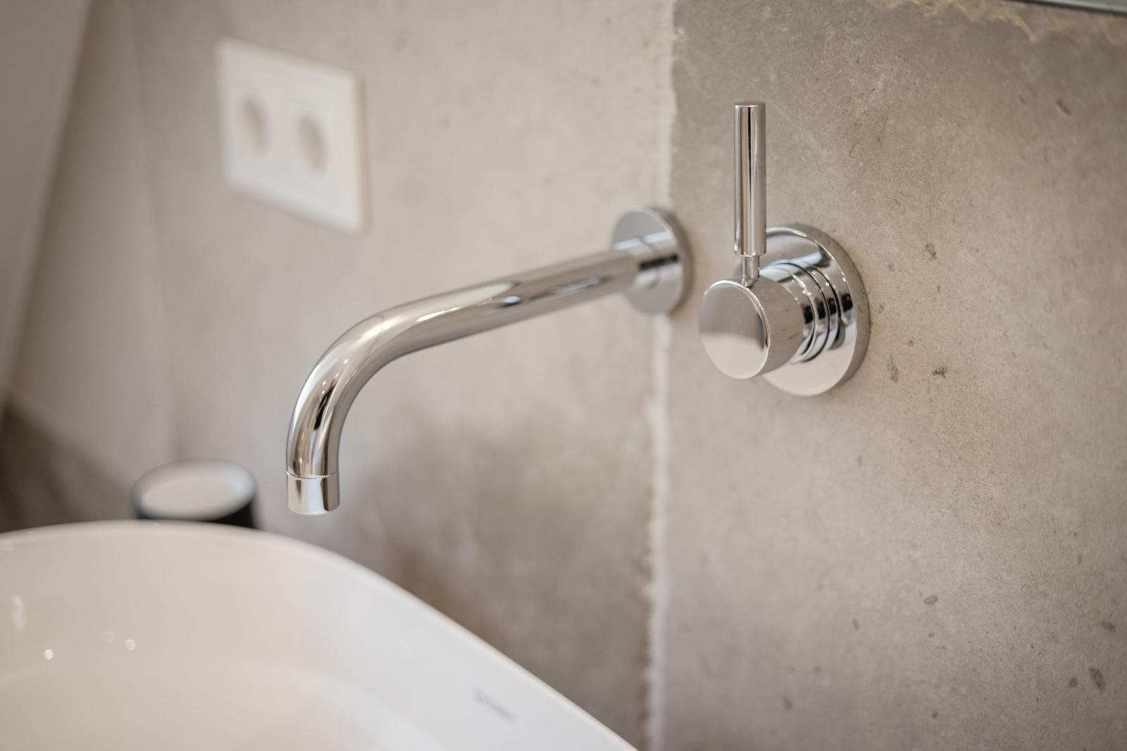 Moderne Waschbecken mit Armatur an Betonwand
