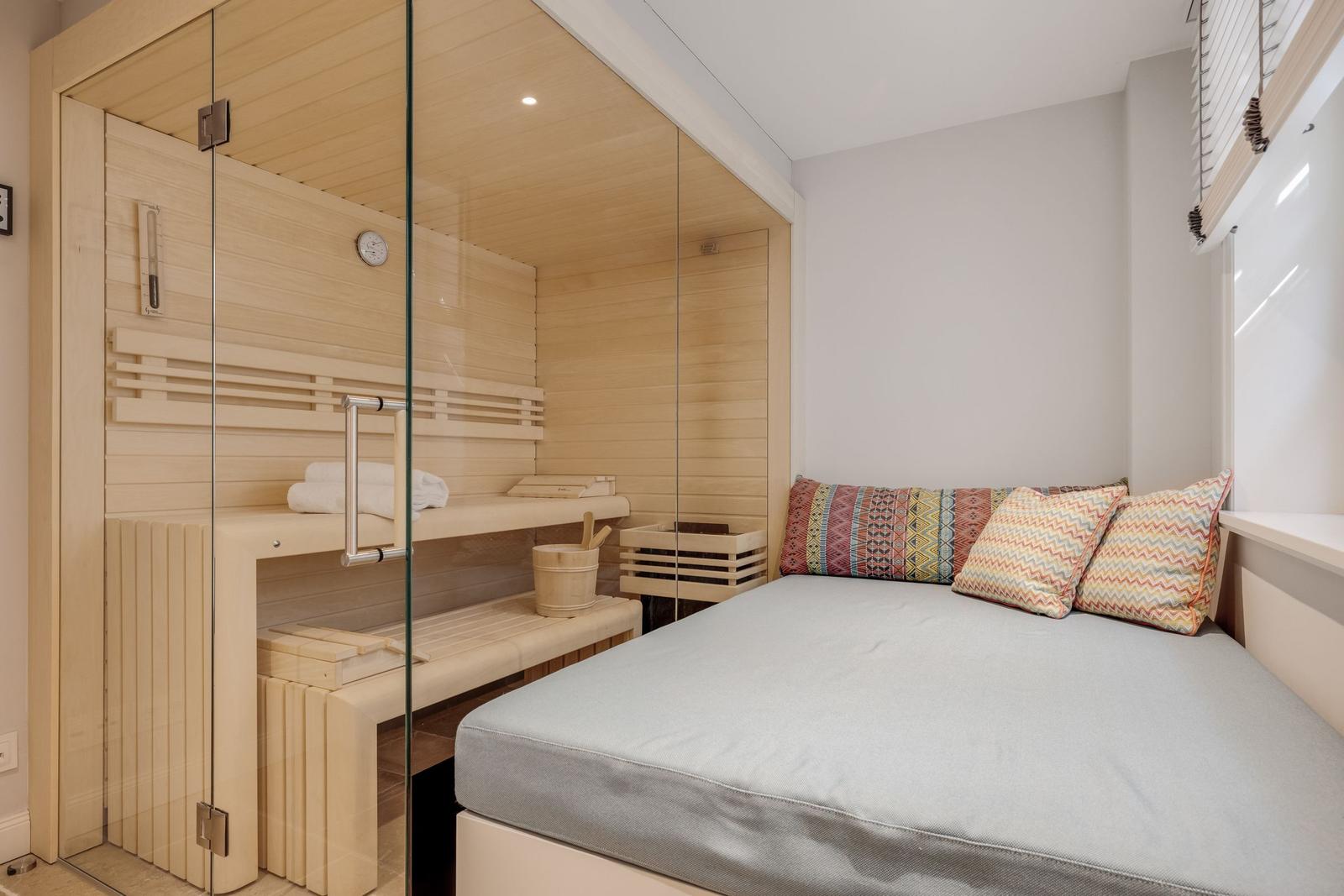 Ein Raum mit einer integrierten Sauna und einem Bett mit Kissen.