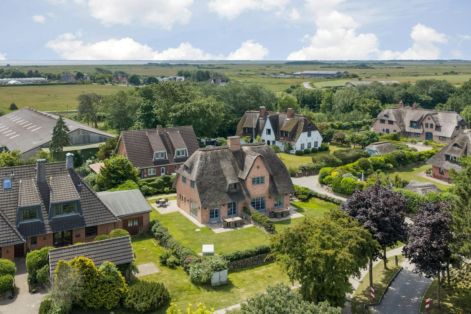 Haus mit Strohdach und Garten in ländlicher Umgebung