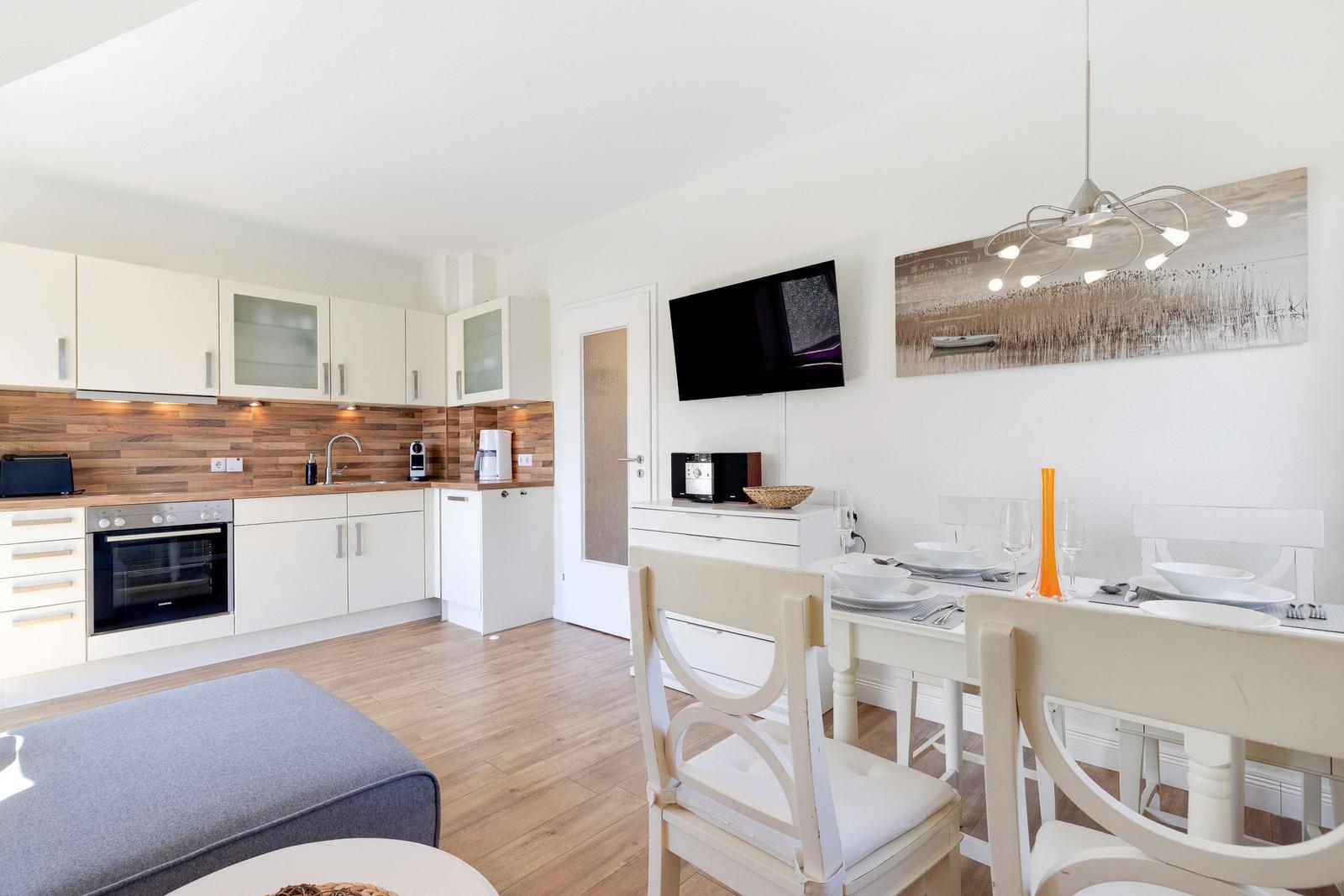 Kitchen with dining area, TV, and modern furnishings.