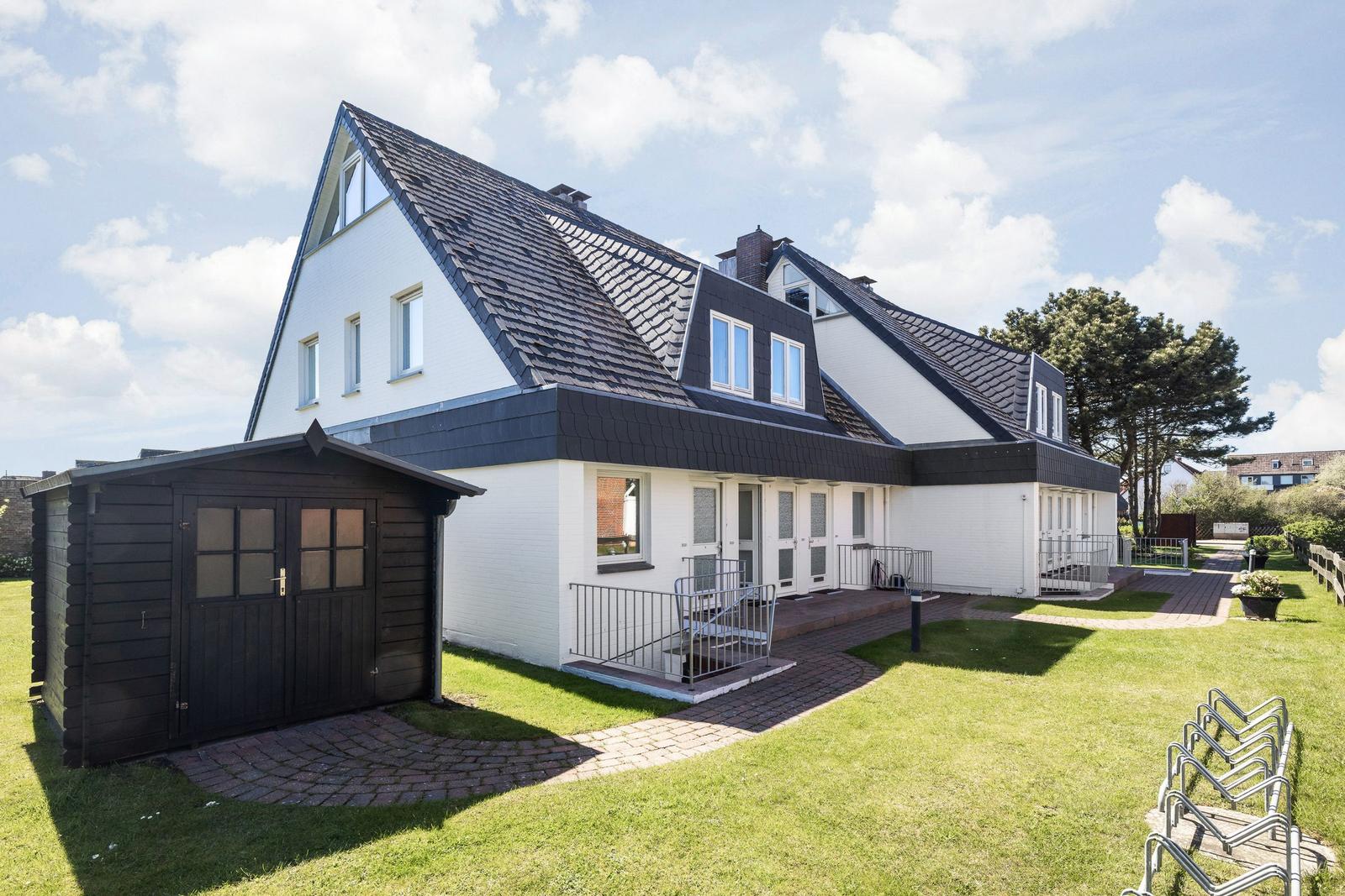 House with attic, garden and garage. Red brick path and bike racks.