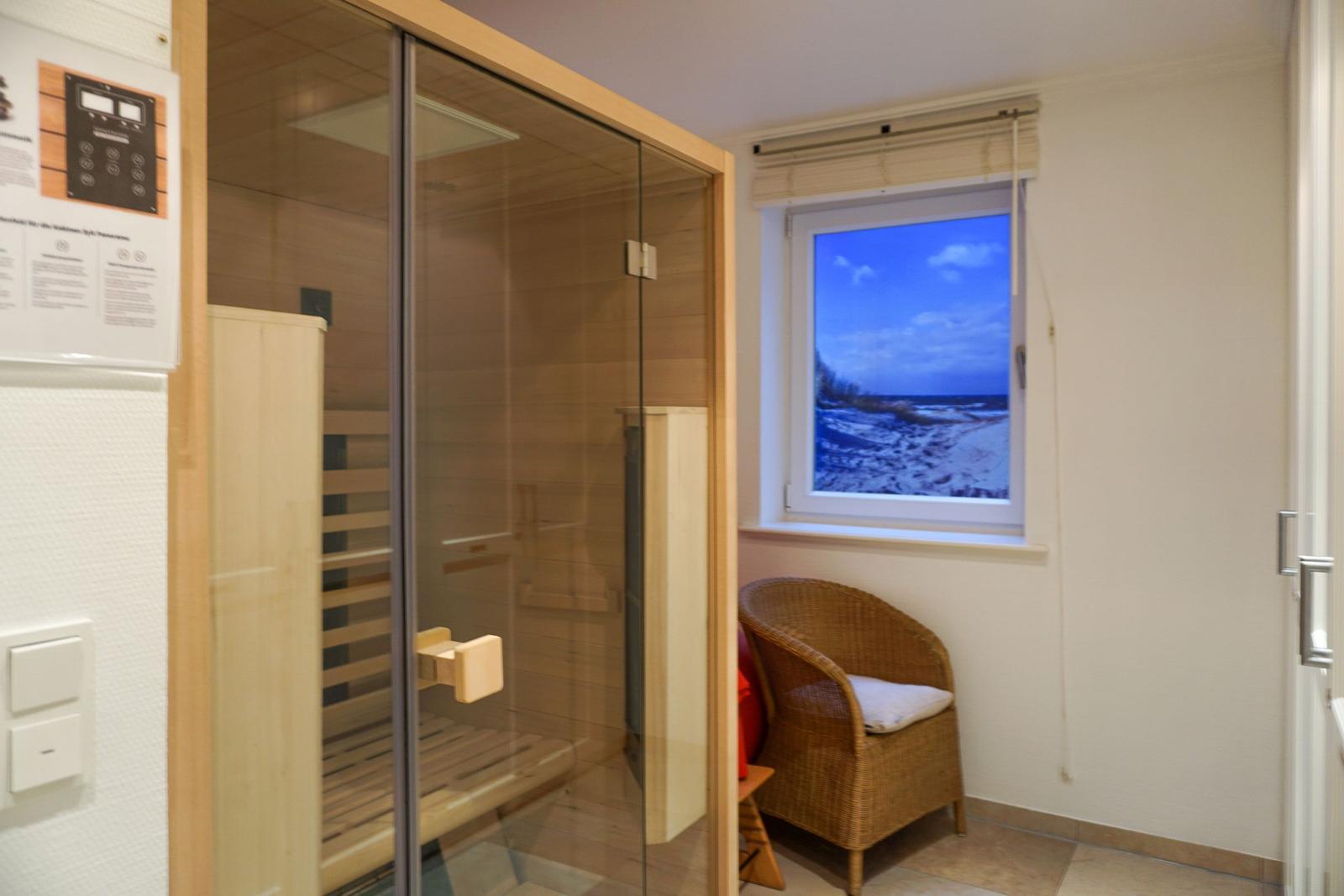 Sauna mit Glaswand, Sitzbank und Fenster mit Meerblick.