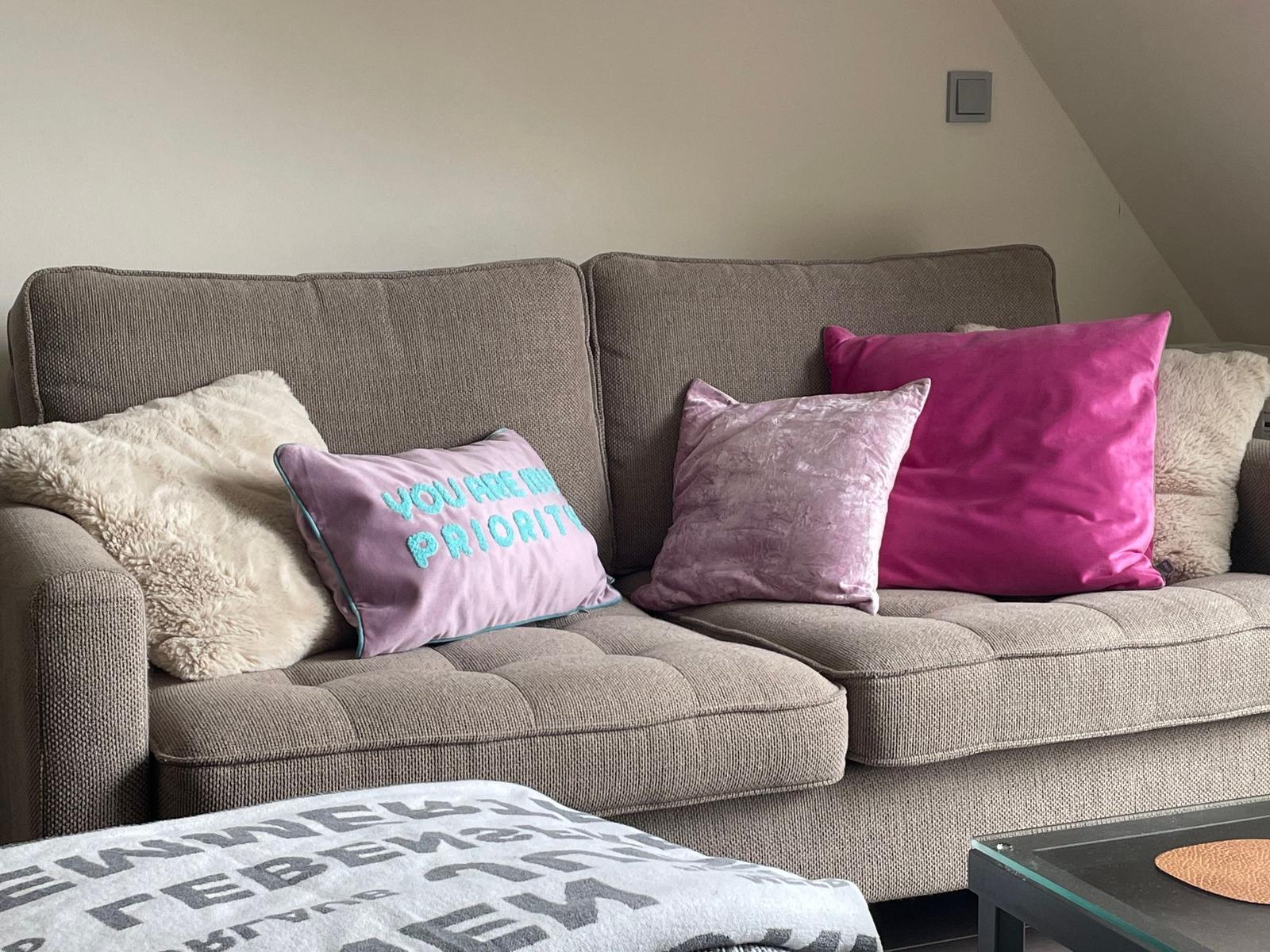 Ein Sofa mit Kissen in verschiedenen Farben und Mustern.
