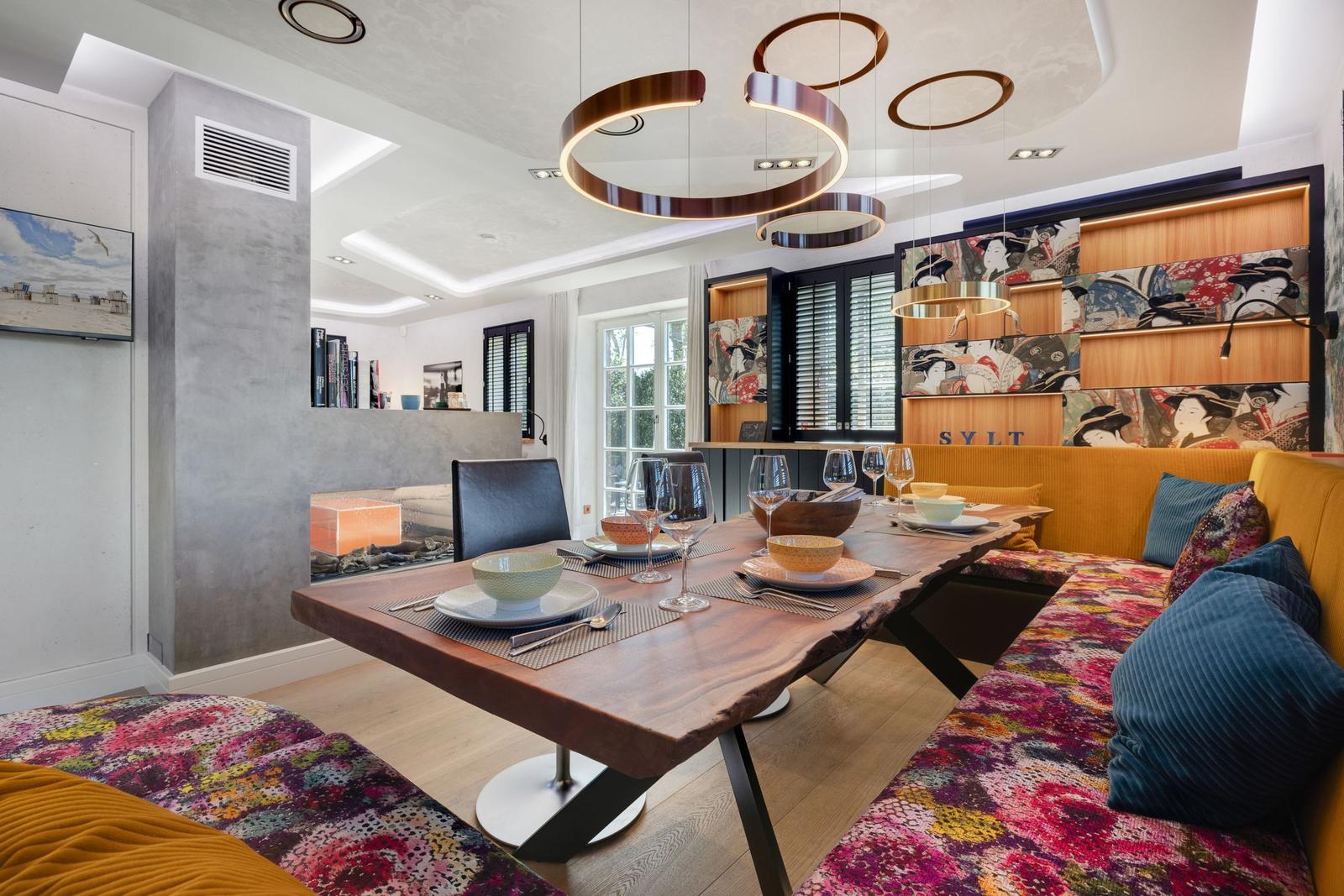 Esszimmer mit Holztisch, Sitzbank und Deckenleuchten