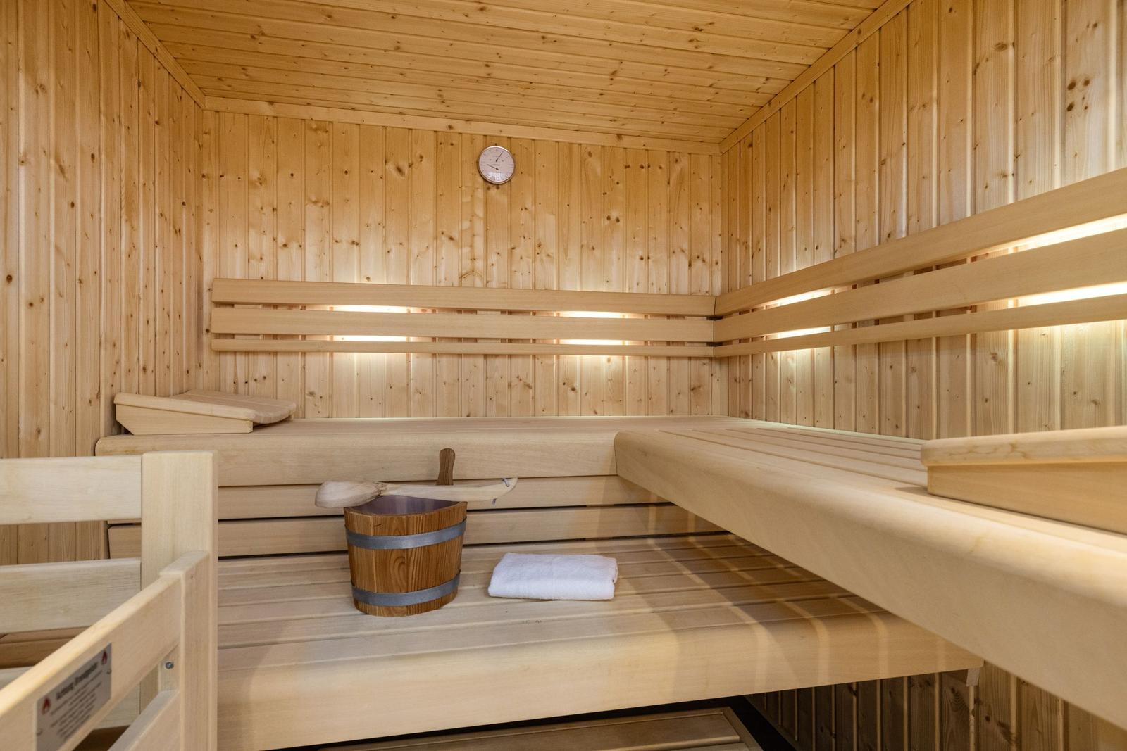 Sauna mit Holzbank, Eimer und Handtuch