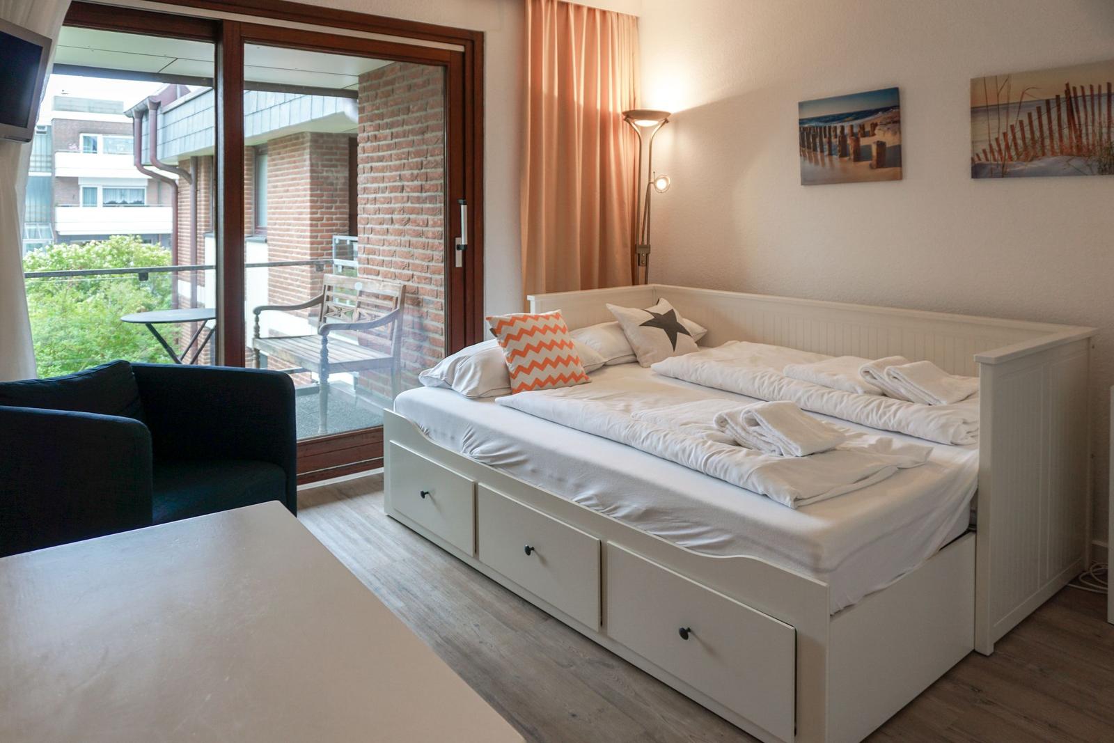 Schlafzimmer mit Doppelbett, Balkon und Wandbildern