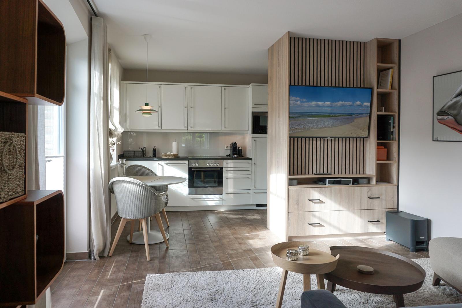 Living kitchen with dining area, TV, and wooden furniture.