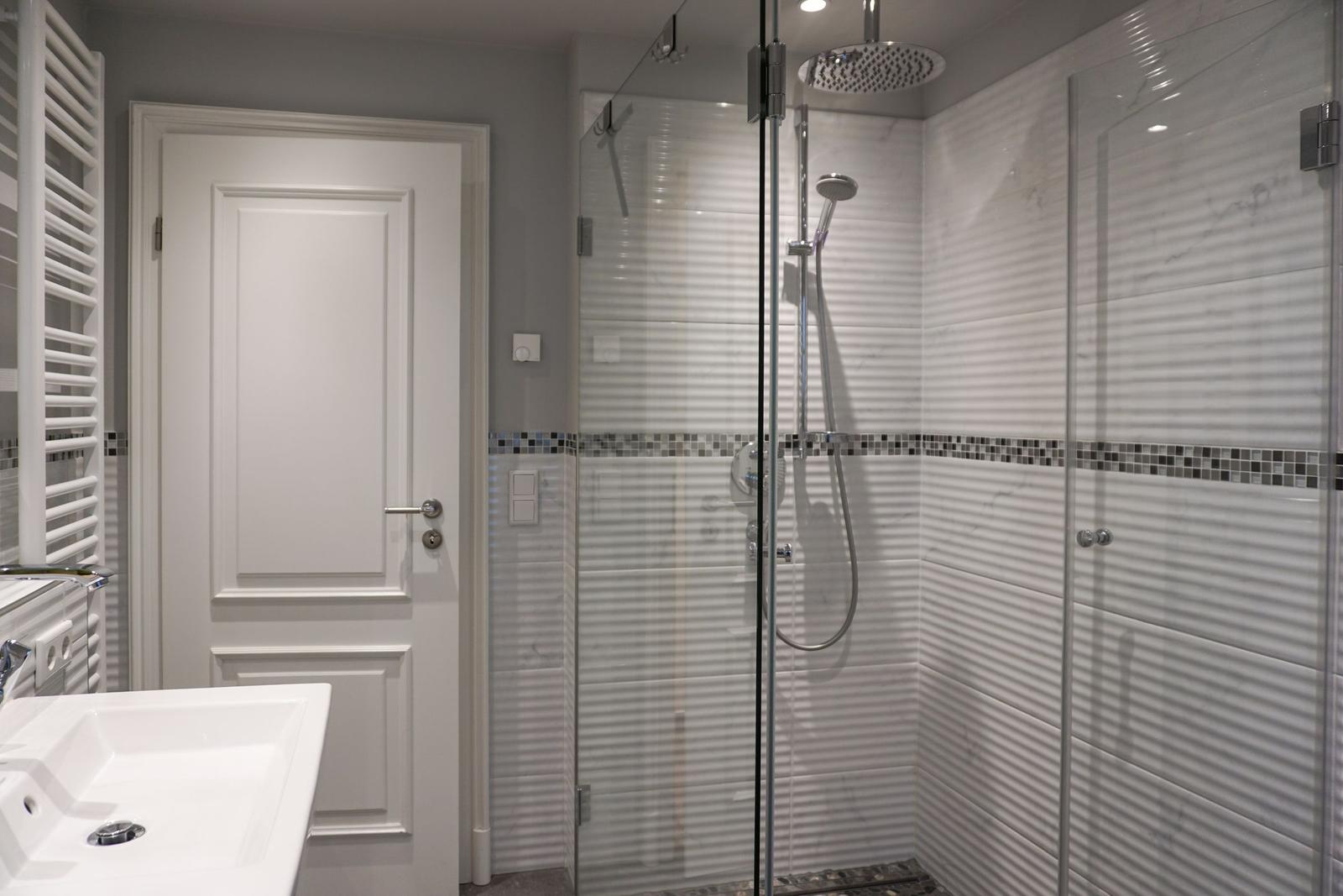 Bathroom with shower stall, sink, and heater