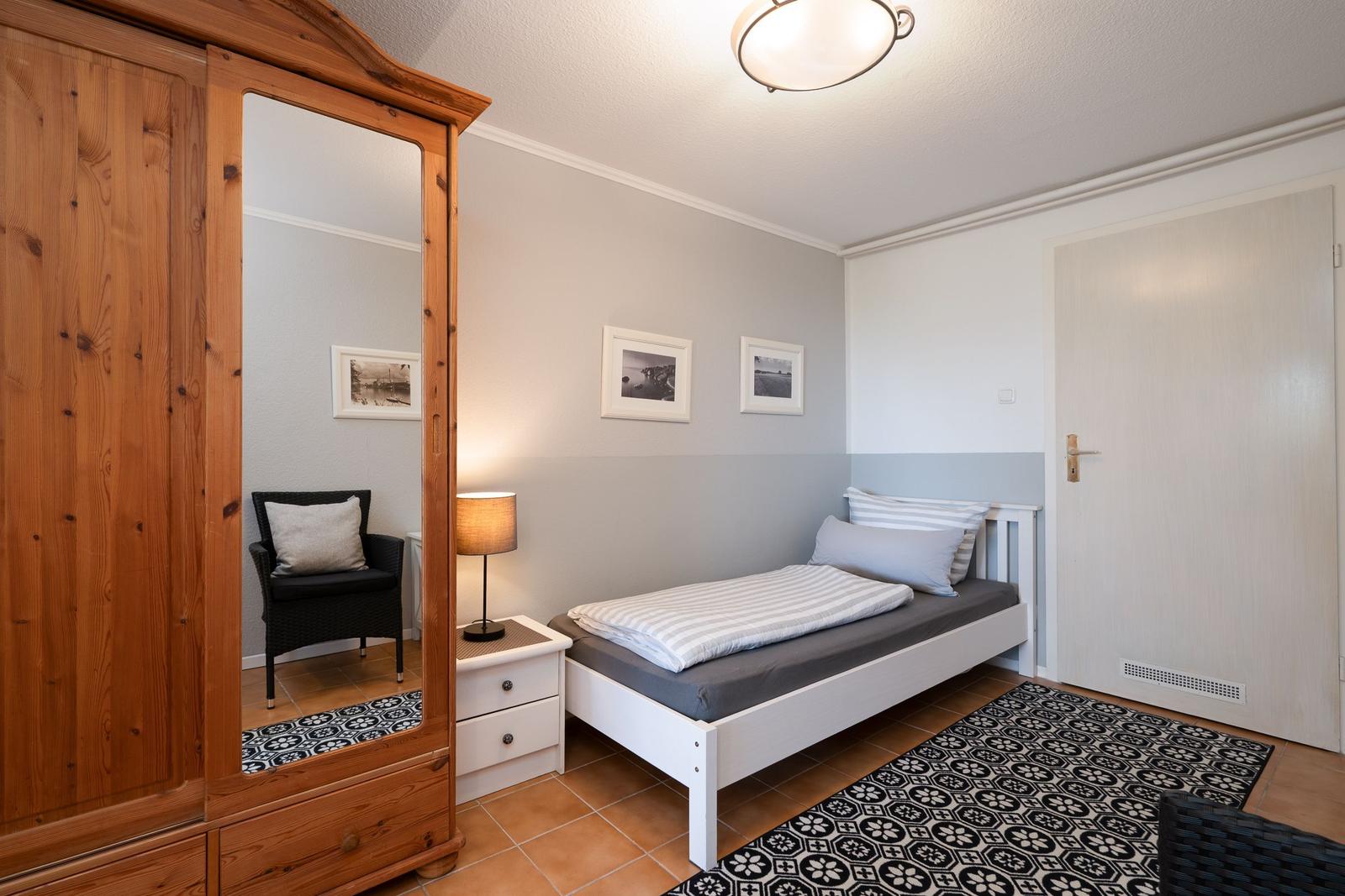 Bedroom with bed, wardrobe, and rug