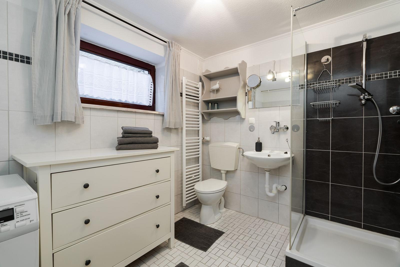 Bathroom with shower, sink, toilet, and washing machine.