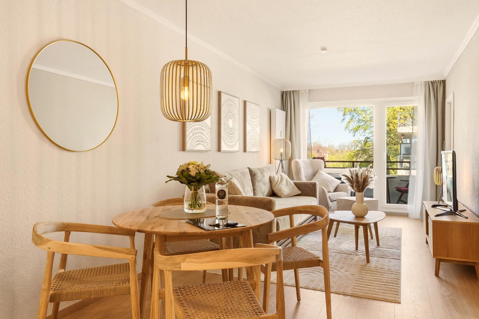 Wohnbereich mit Esstisch, Sofa und Balkon. Holzmöbel und moderne Beleuchtung.