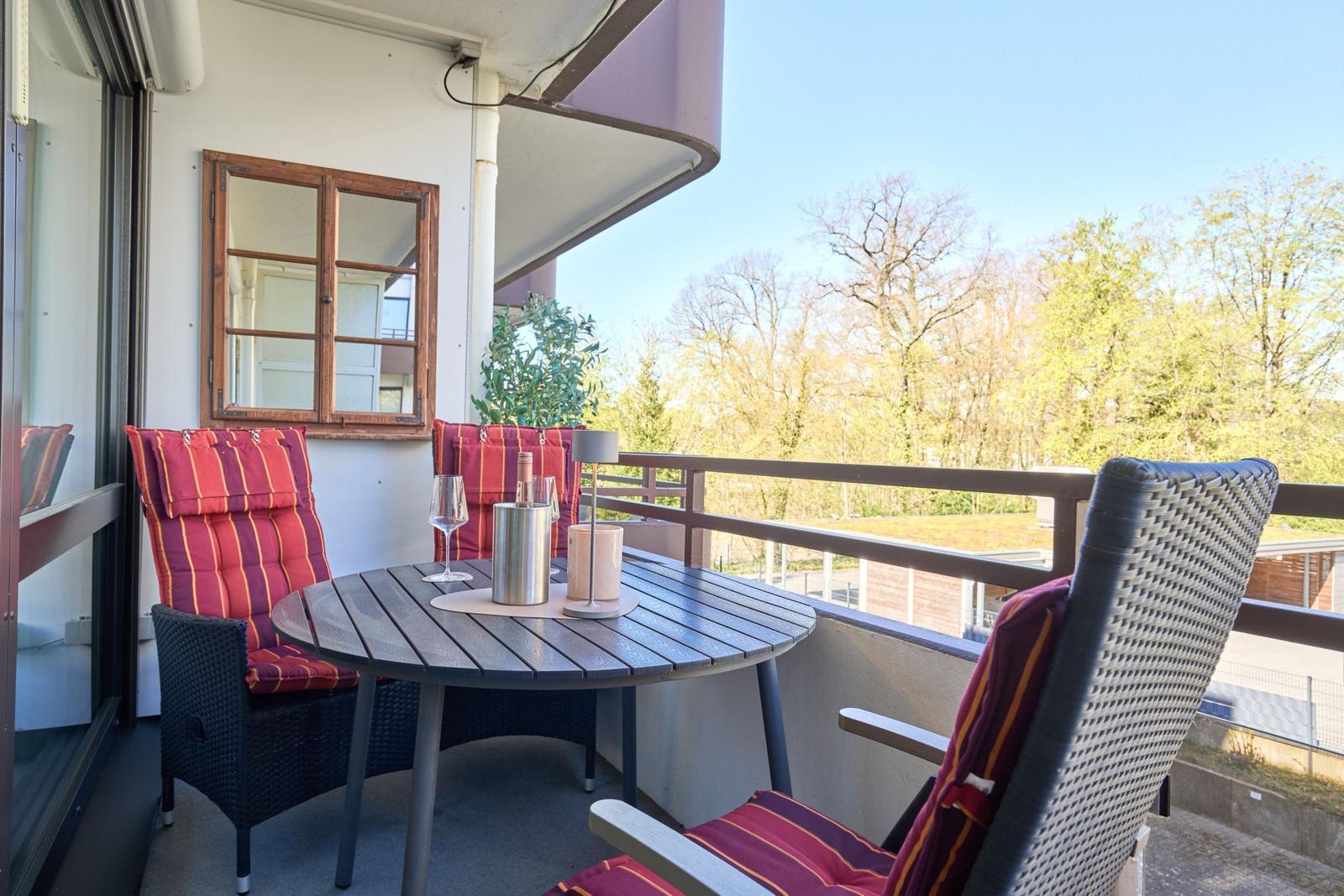 Terrasse mit Tisch und Stühlen, Blick auf Bäume und Himmel