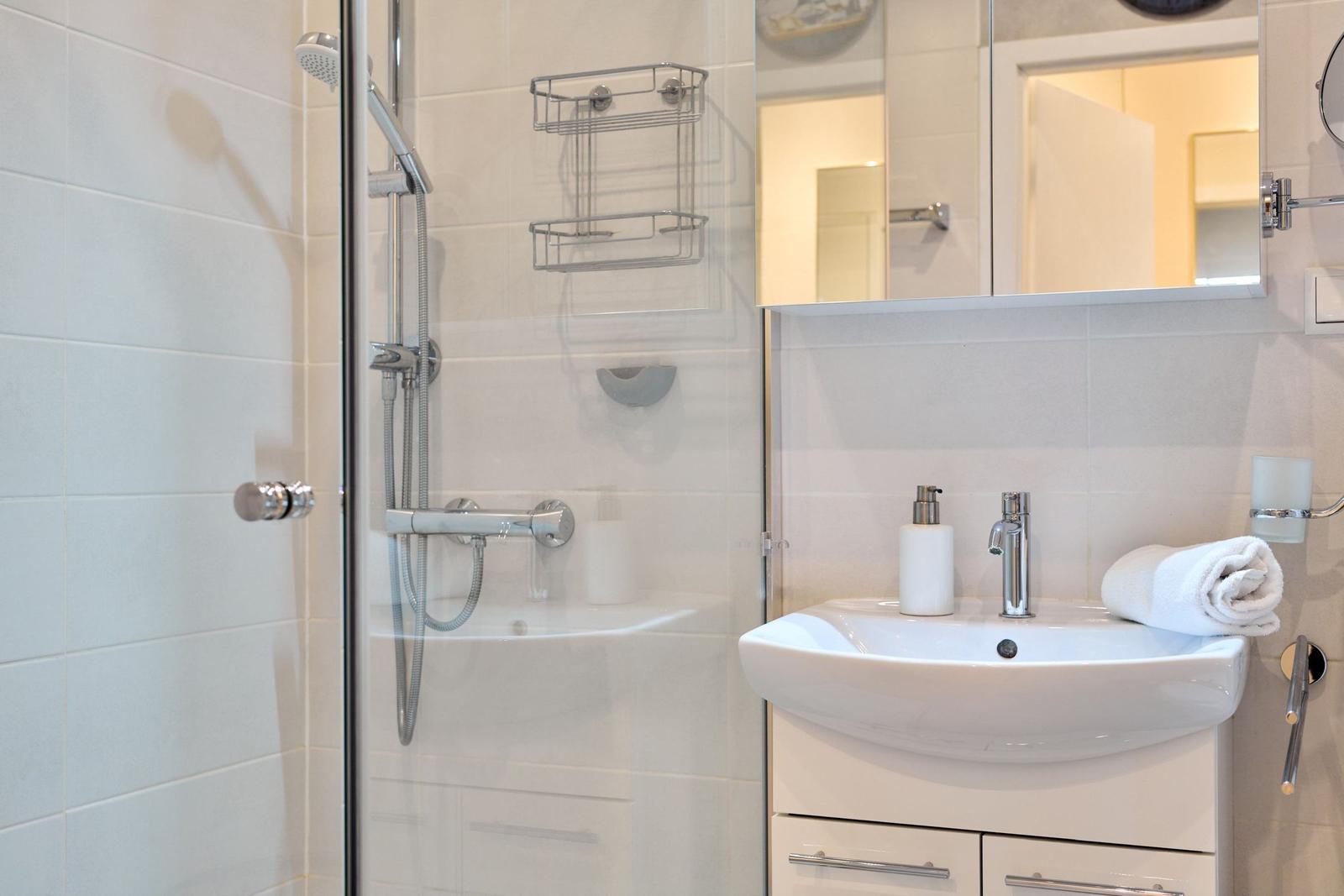 Bad mit Dusche, Waschbecken und Spiegel