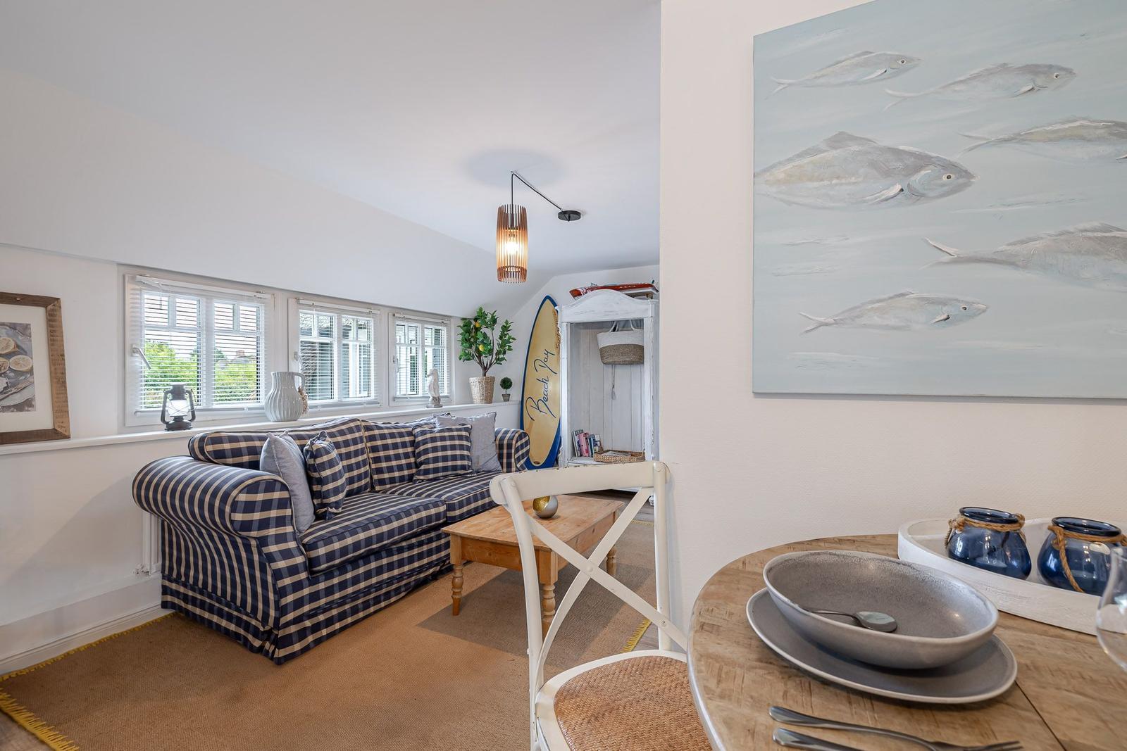 Wohnzimmer mit Sofa, Tisch und Wandbild. Essbereich mit Tisch und Stuhl.