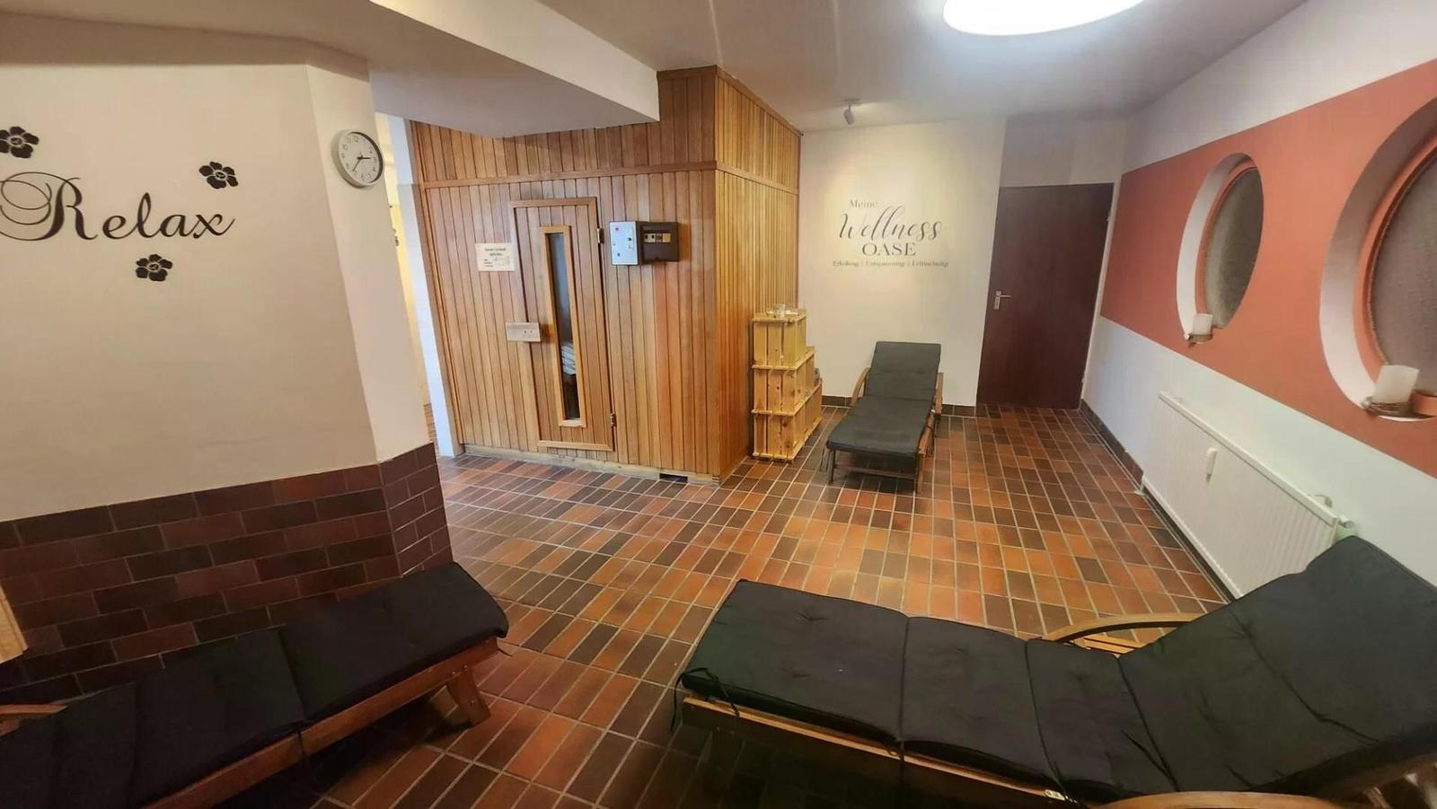 Wellnessbereich mit Sauna, Liegen und Wanddekoration.