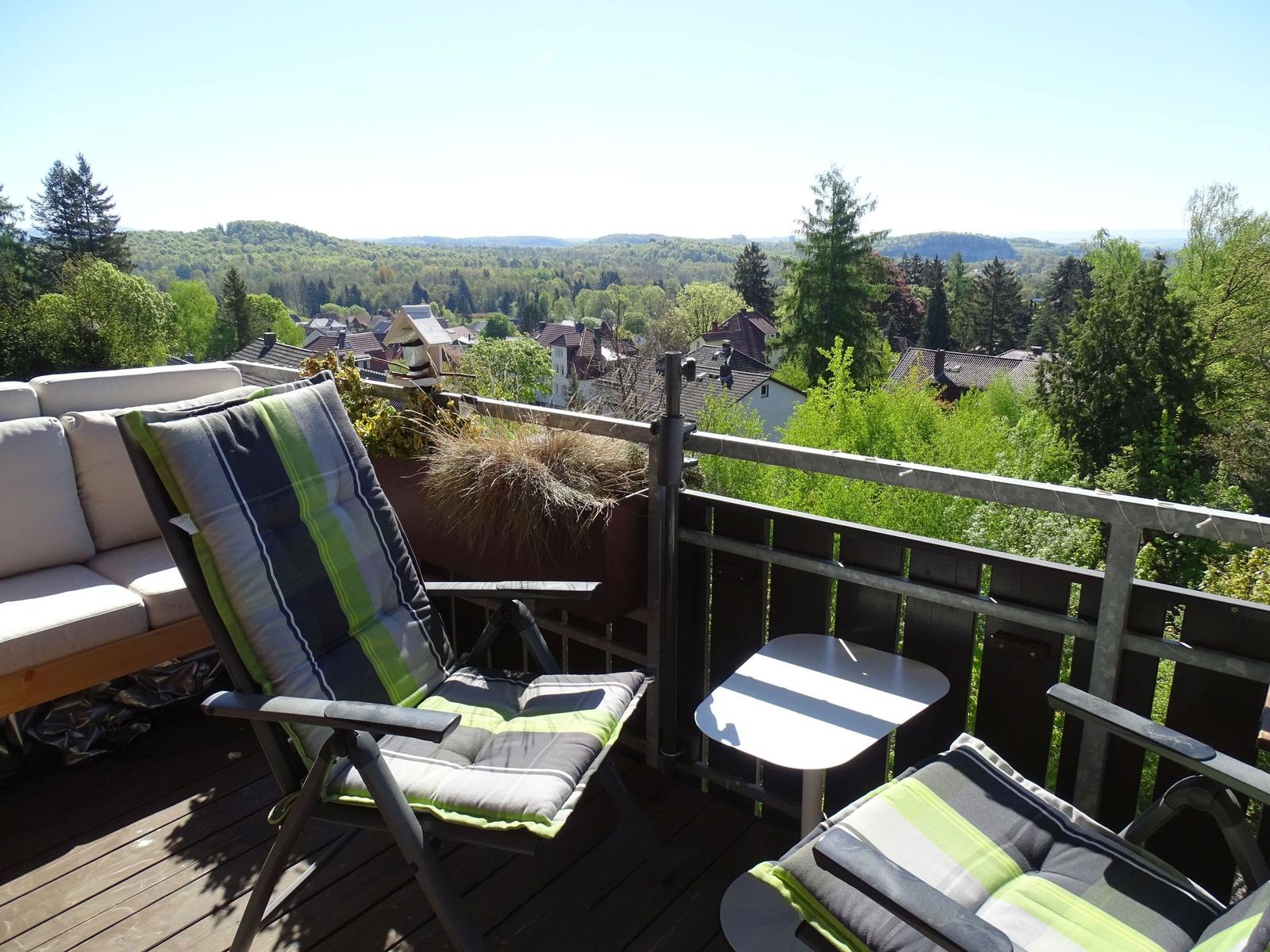 Terrasse mit Liegestühlen und Blick auf Wald und Dörfer.
