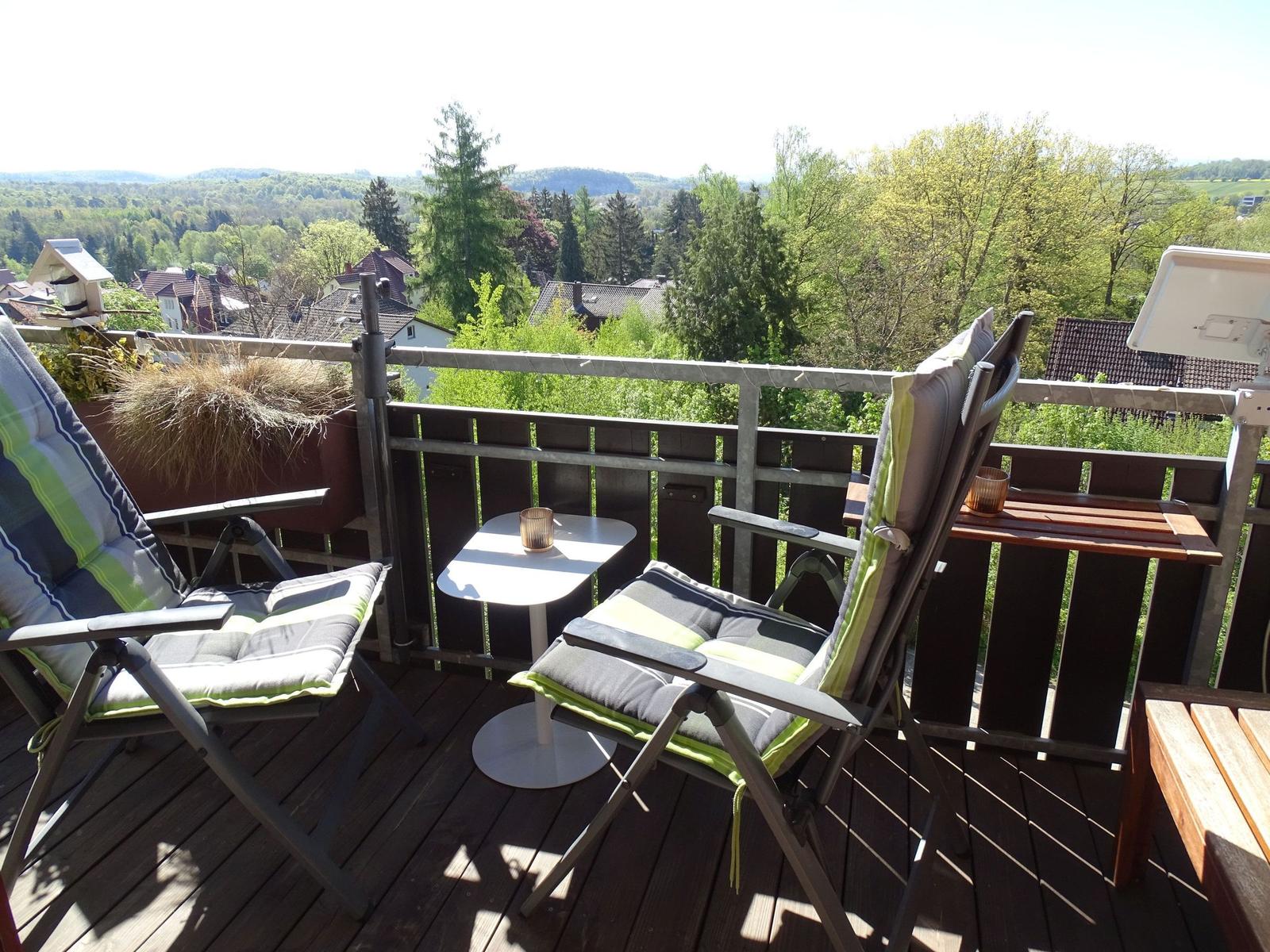 Terrasse mit zwei Liegestühlen, Tisch und Aussicht auf grüne Landschaft.