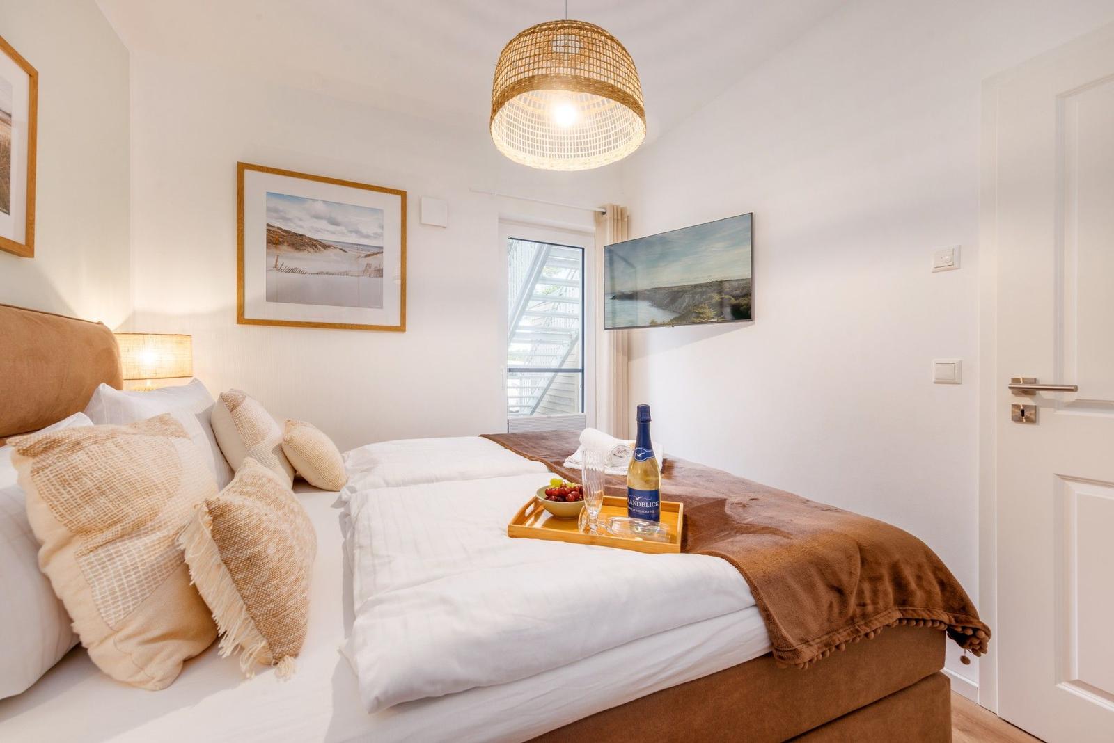 Schlafzimmer mit Bett, Decke, Kissen und Flasche auf dem Bett.