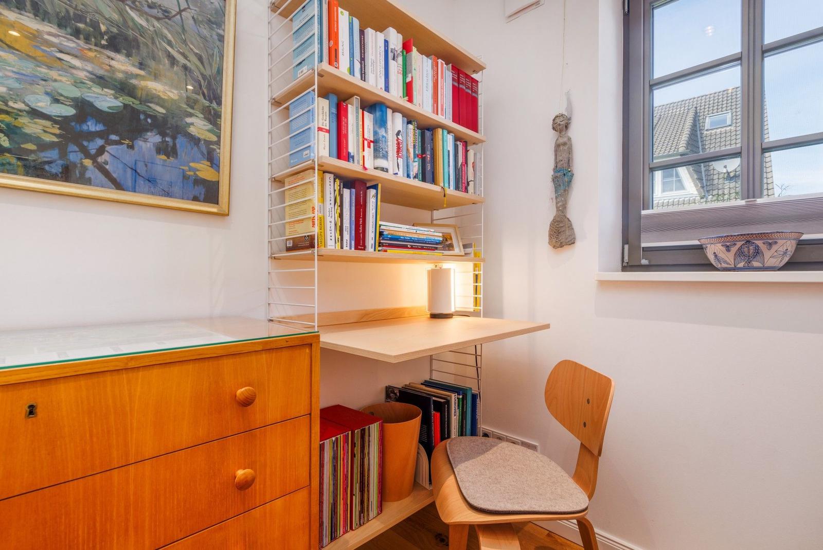 Arbeitsplatz mit Bücherregal, Stuhl und Fenster mit Blick.